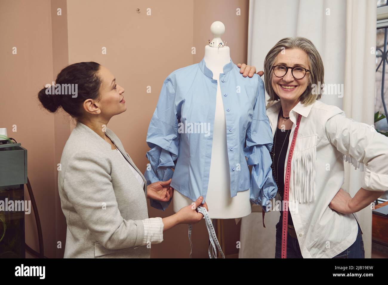 Créateurs de mode travaillant avec un mannequin dans un atelier de design de mode. Personnalisation, création d'une nouvelle collection de vêtements, design de mode entreprise start-u Banque D'Images