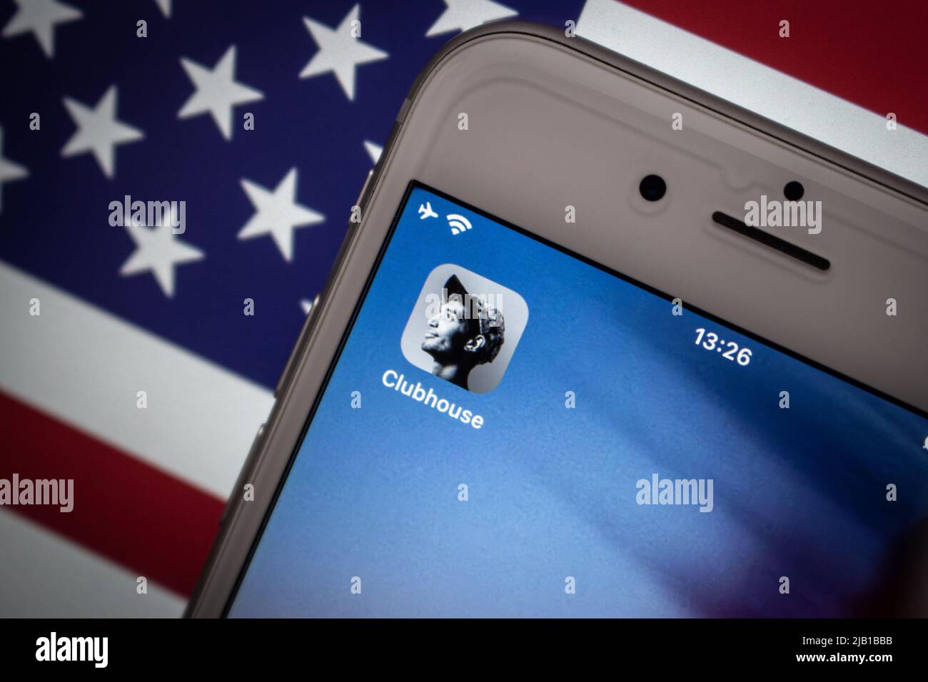 Kumamoto, JAPON - Fév 15 2021 : concept image application Clubhouse sur l'écran de l'iPhone avec arrière-plan drapeau américain. Banque D'Images