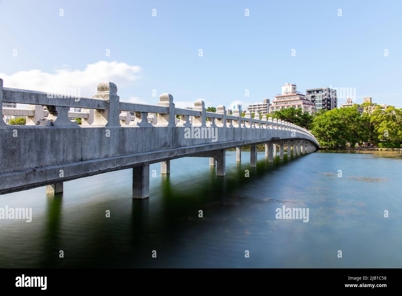 Photo en longue exposition du pont de Kangetsu au parc Ohori avec un étang, par beau temps. Le parc actuel a été conçu sur le modèle du lac Ouest de Chine et a ouvert ses portes en 1929 Banque D'Images