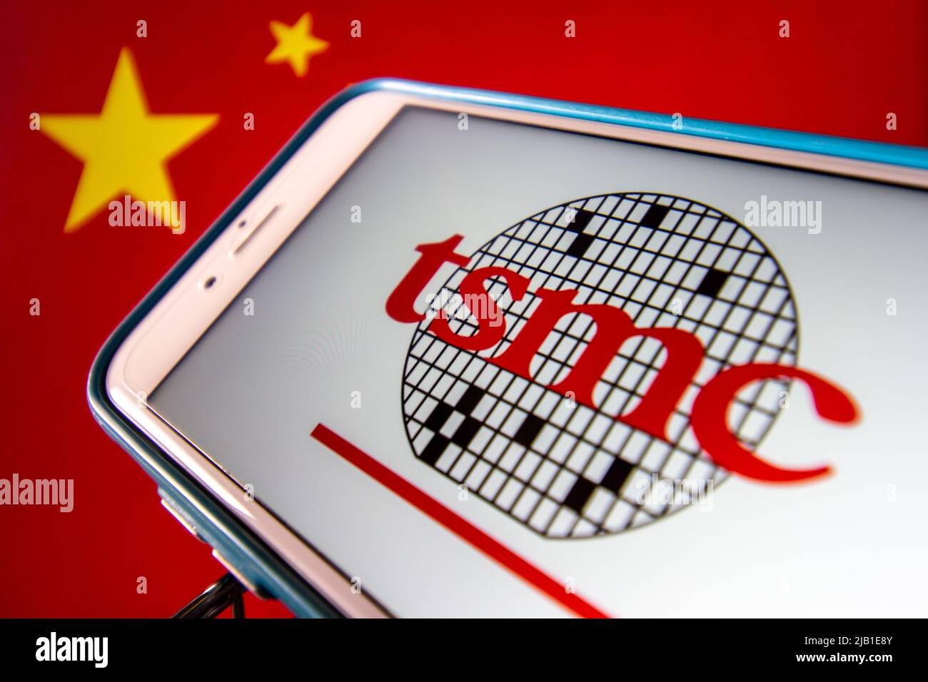 Kumamoto, JAPON - avril 20 2021 : le logo de Taiwan Semiconductor Manufacturing Company, Limited (TSMC) sur iPhone sur drapeau chinois. Banque D'Images