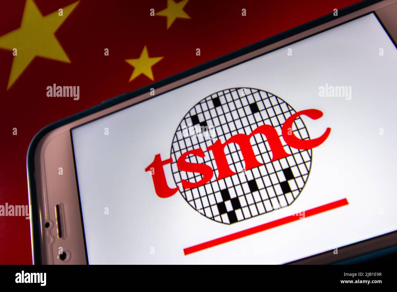 Kumamoto, JAPON - avril 20 2021 : le logo de Taiwan Semiconductor Manufacturing Company, Limited (TSMC) sur iPhone sur drapeau chinois. Banque D'Images