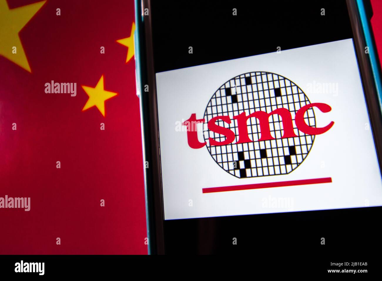 Kumamoto, JAPON - avril 20 2021 : le logo de Taiwan Semiconductor Manufacturing Company, Limited (TSMC) sur iPhone sur drapeau chinois. Banque D'Images