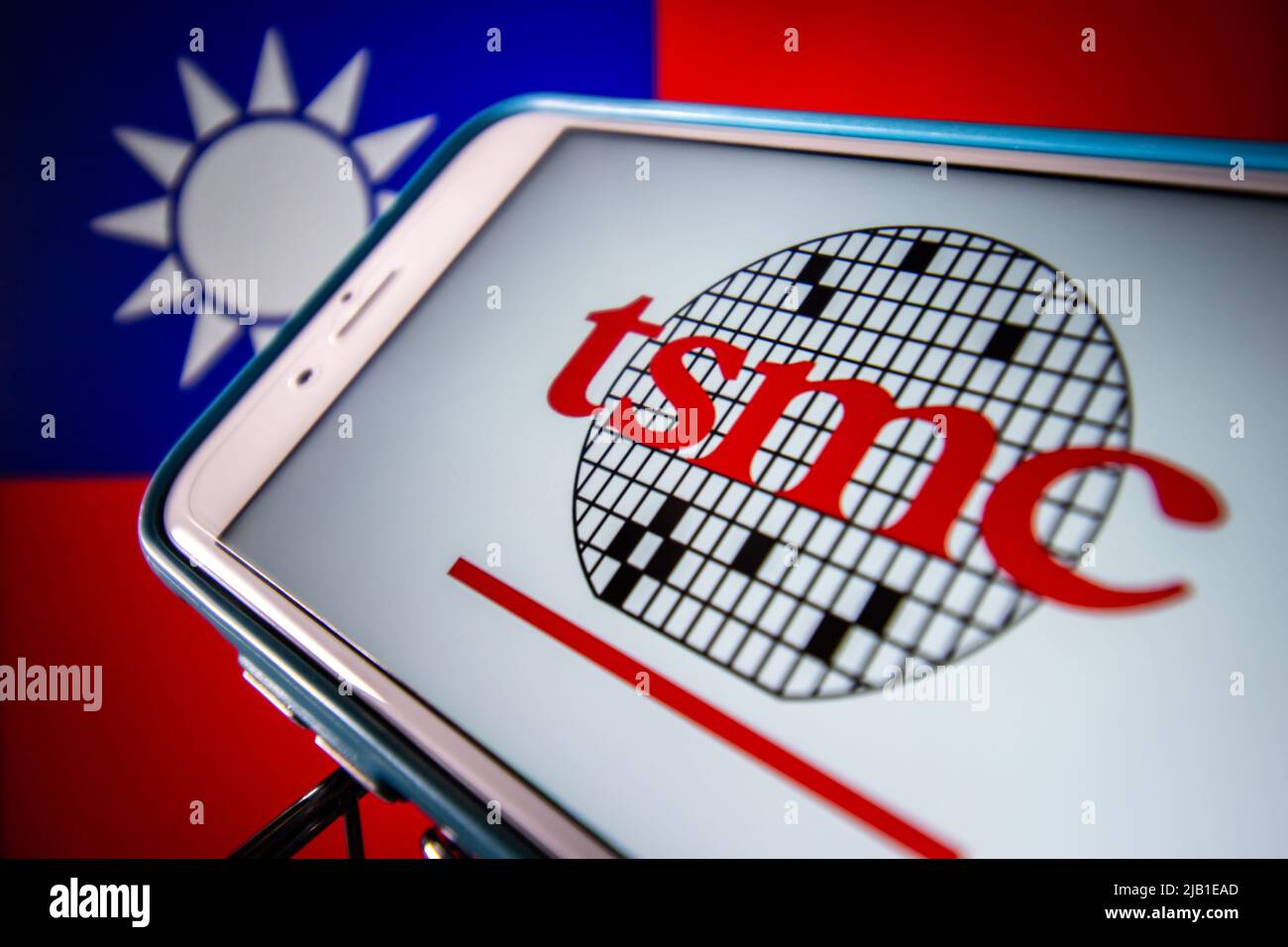 Kumamoto, JAPON - avril 20 2021 : le logo de Taiwan Semiconductor Manufacturing Company, Limited (TSMC) sur iPhone sur drapeau taïwanais. Banque D'Images