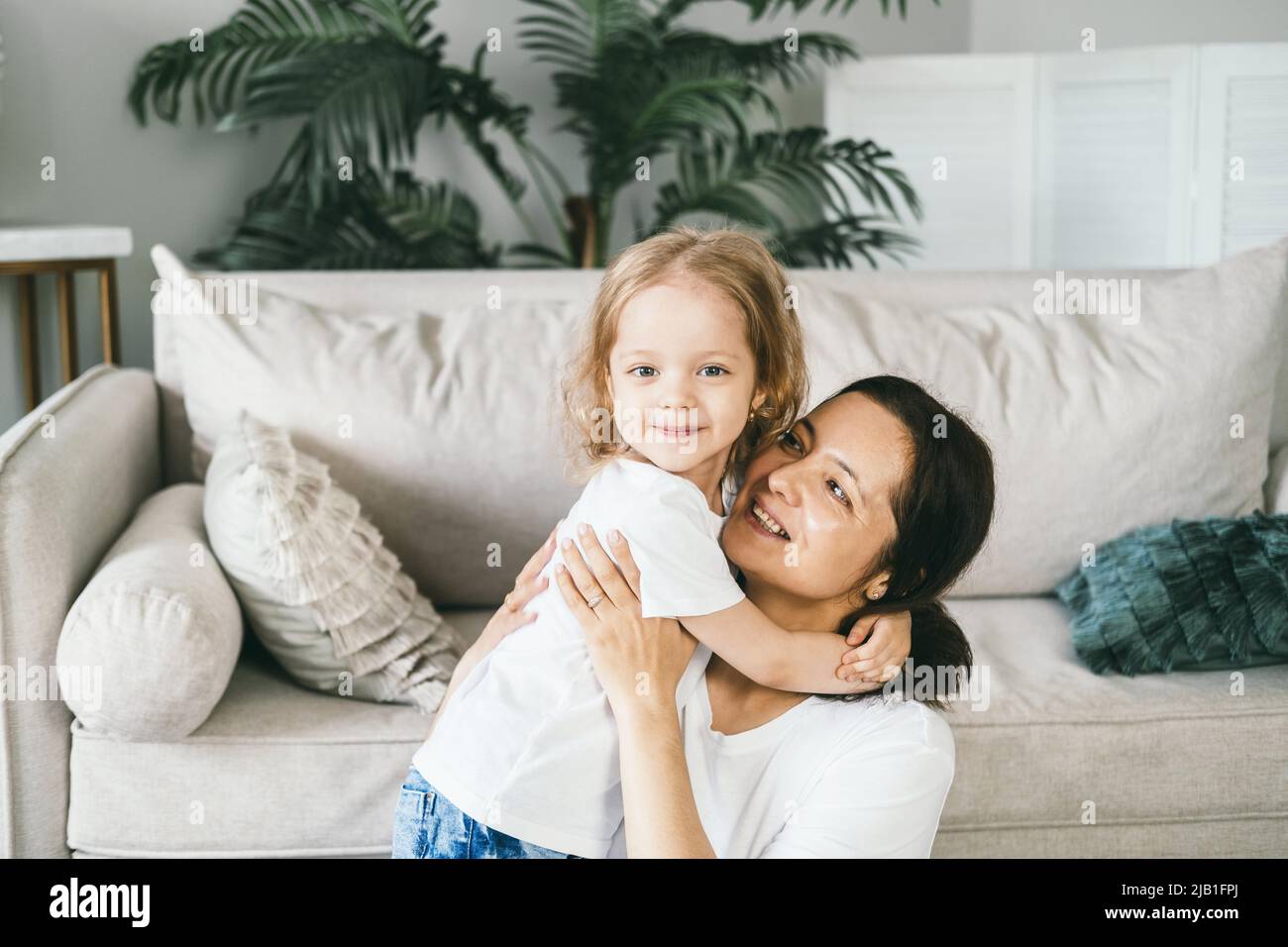 Une mère épouse doucement sa fille de quatre ans. Banque D'Images