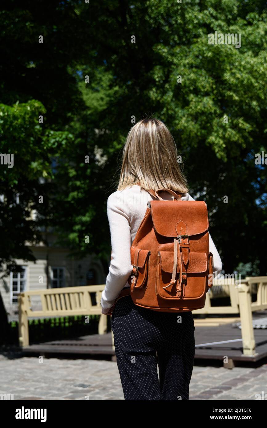 Femme avec un sac à dos en cuir orange avec un look ancien et rétro. Photo  à l'extérieur Photo Stock - Alamy