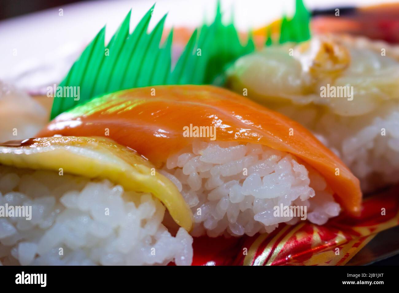 Les sushis au saumon sont en gros plan avec les sushis Anago (conger anguille) et Kai (mollusques) dans un pack de sushis à emporter. Banque D'Images