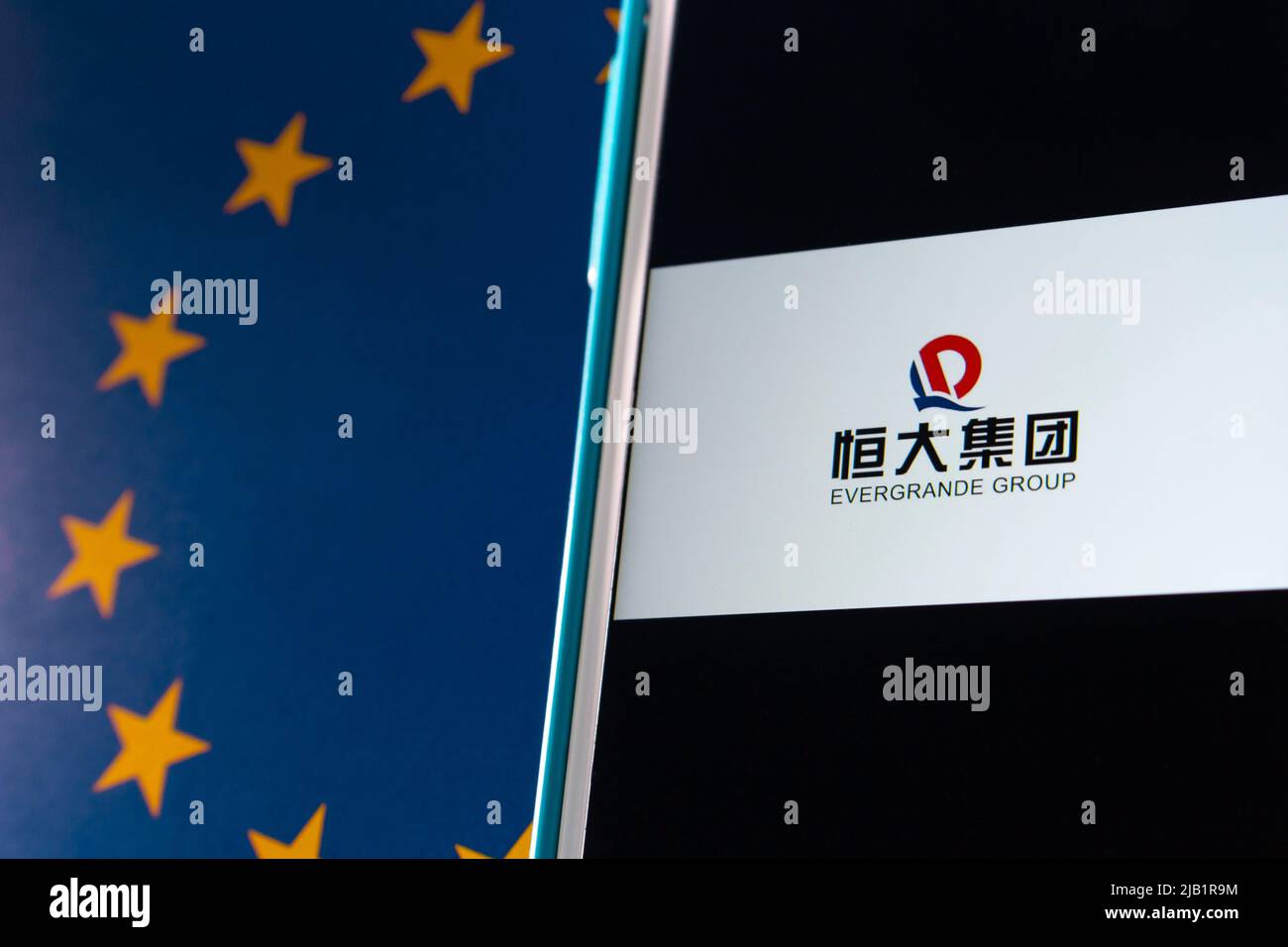 Kumamoto, JAPON - septembre 24 2021 : le principal promoteur immobilier chinois, le logo du Groupe Evergrande (ou Groupe immobilier Evergrande) sur iPhone, drapeau de l'UE Banque D'Images