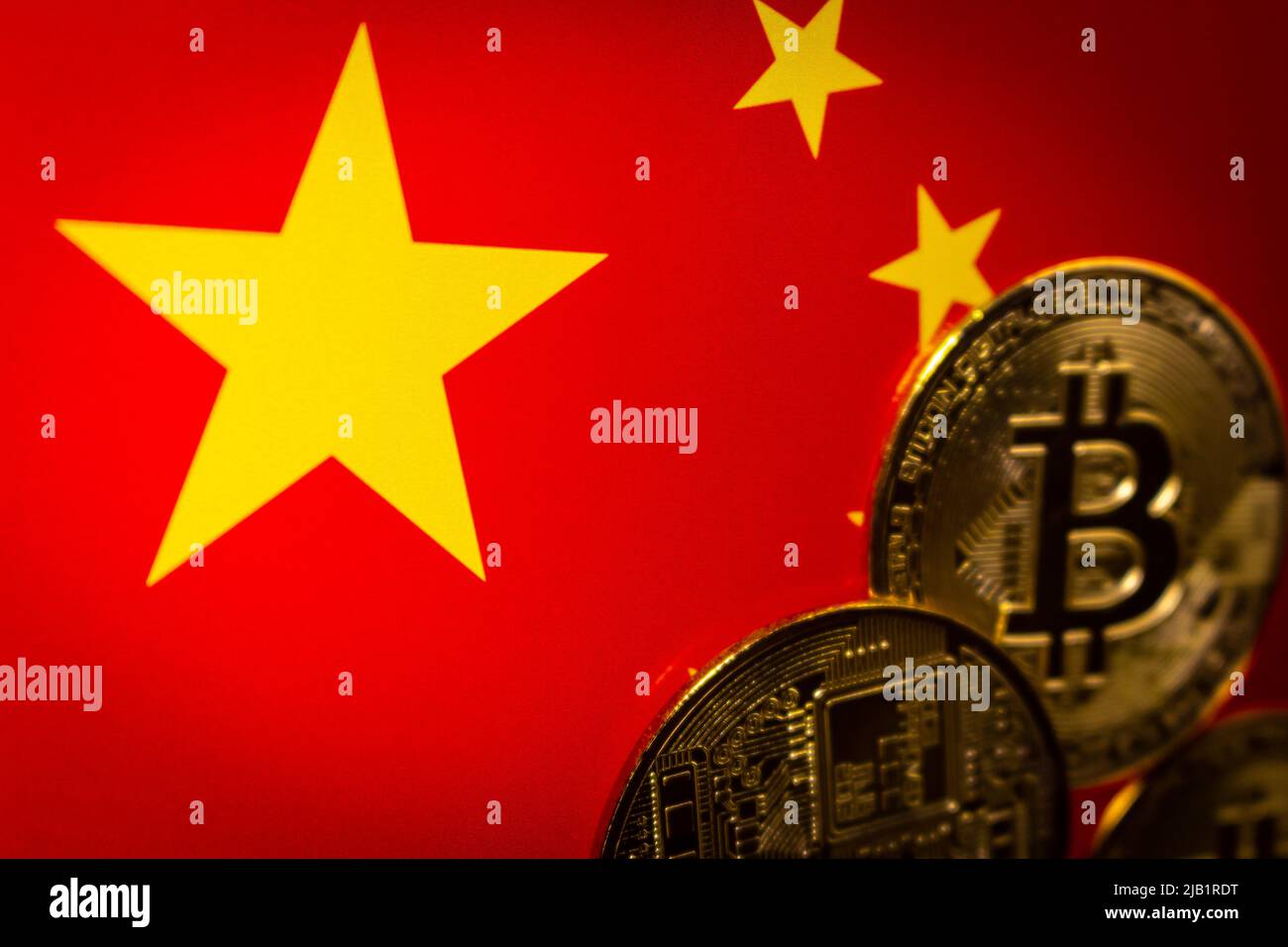 Gros plan étoiles sur fond de drapeau chinois avec bitcoins flous d'humeur sombre. Le concept de crypto-monnaie interdite en chine. Banque D'Images