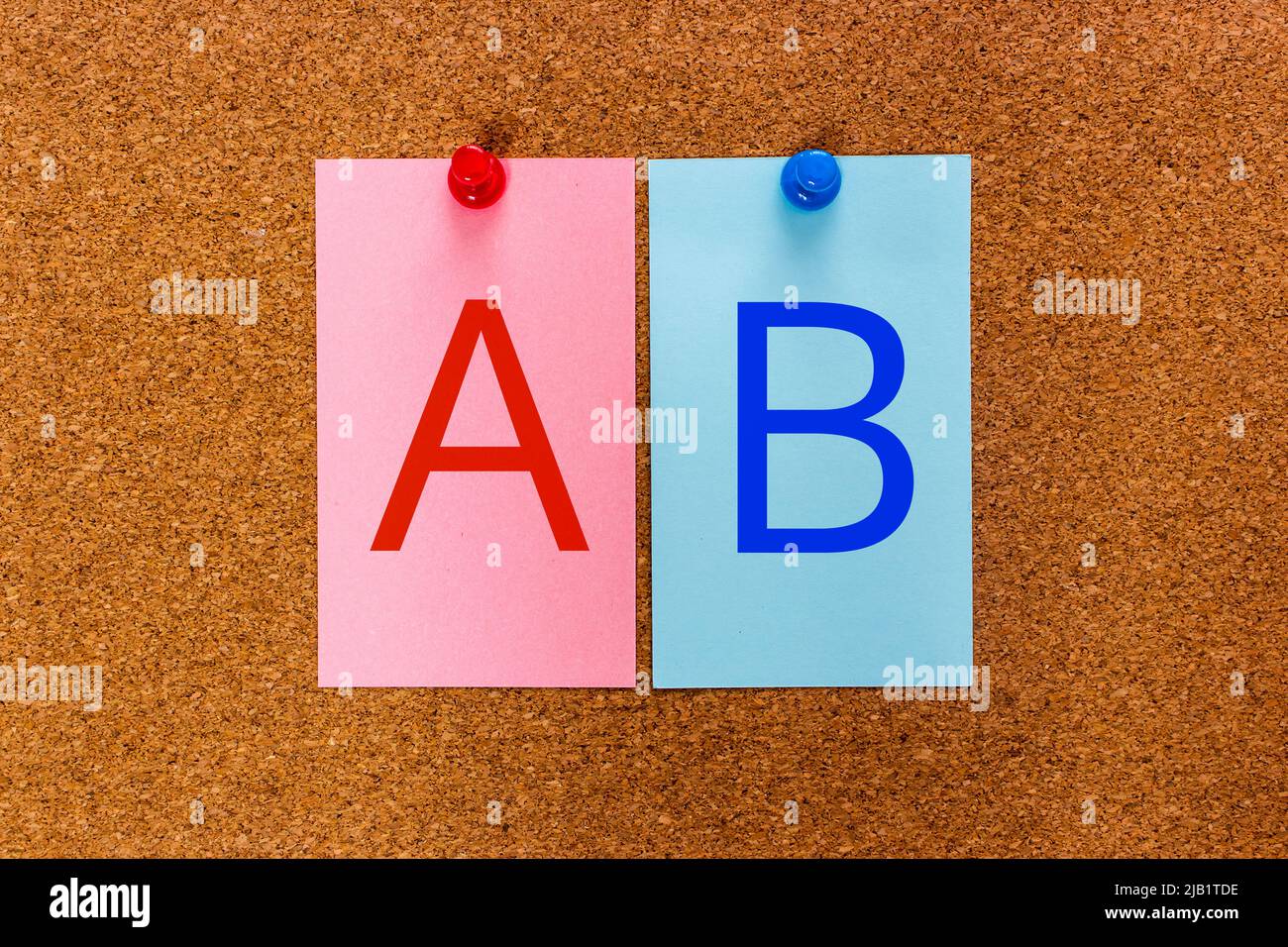 Conceptuel 2 lettres AB sur des autocollants multicolores attachés à un panneau en liège. Expérience utilisateur méthodologie de recherche AB test. Banque D'Images