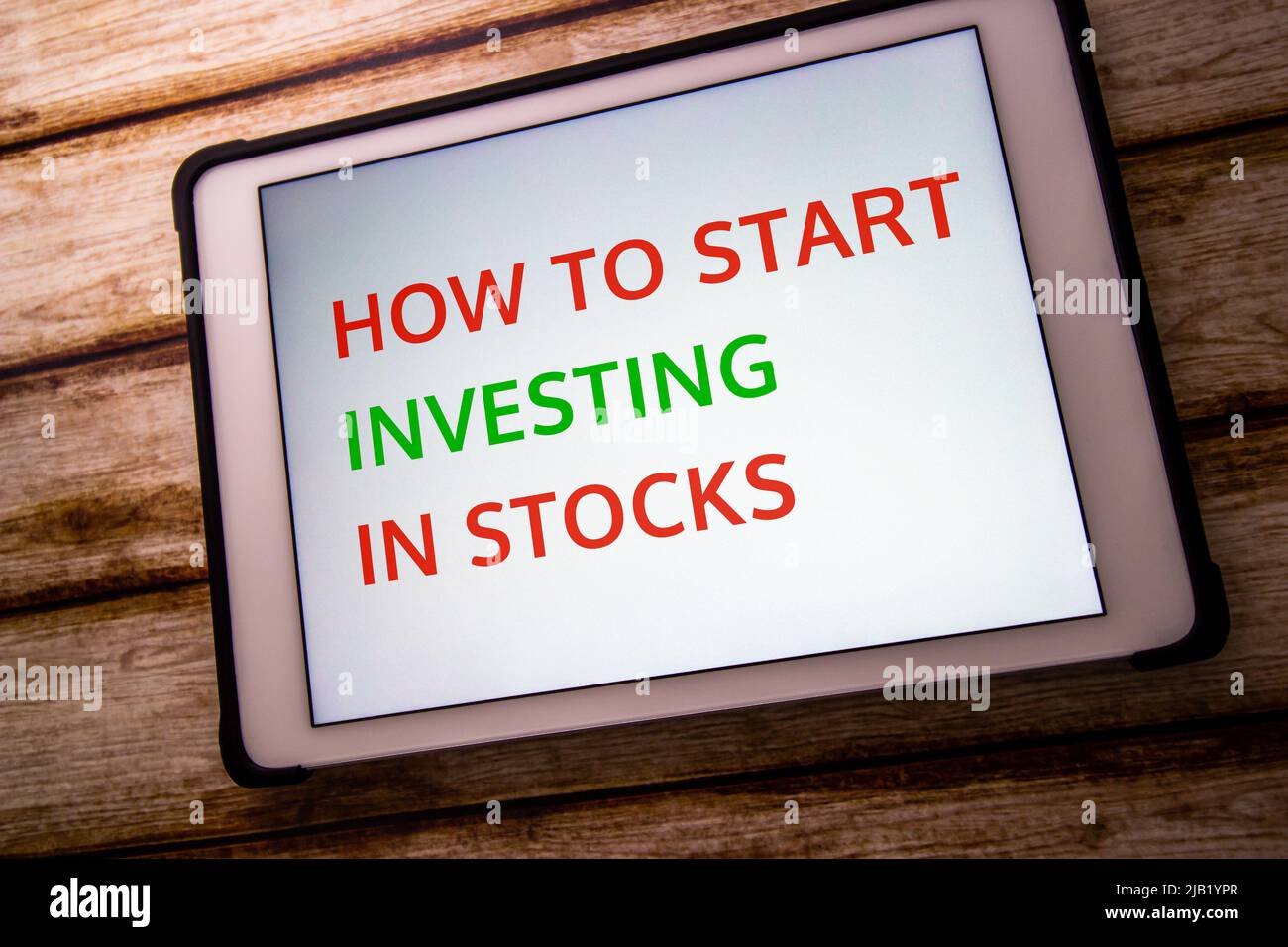 Mot-clé “Comment commencer à investir dans les actions” sur tablette sur table de rafée. Investissement dans les stocks. Introduction, pratique, concept d'apprentissage Banque D'Images