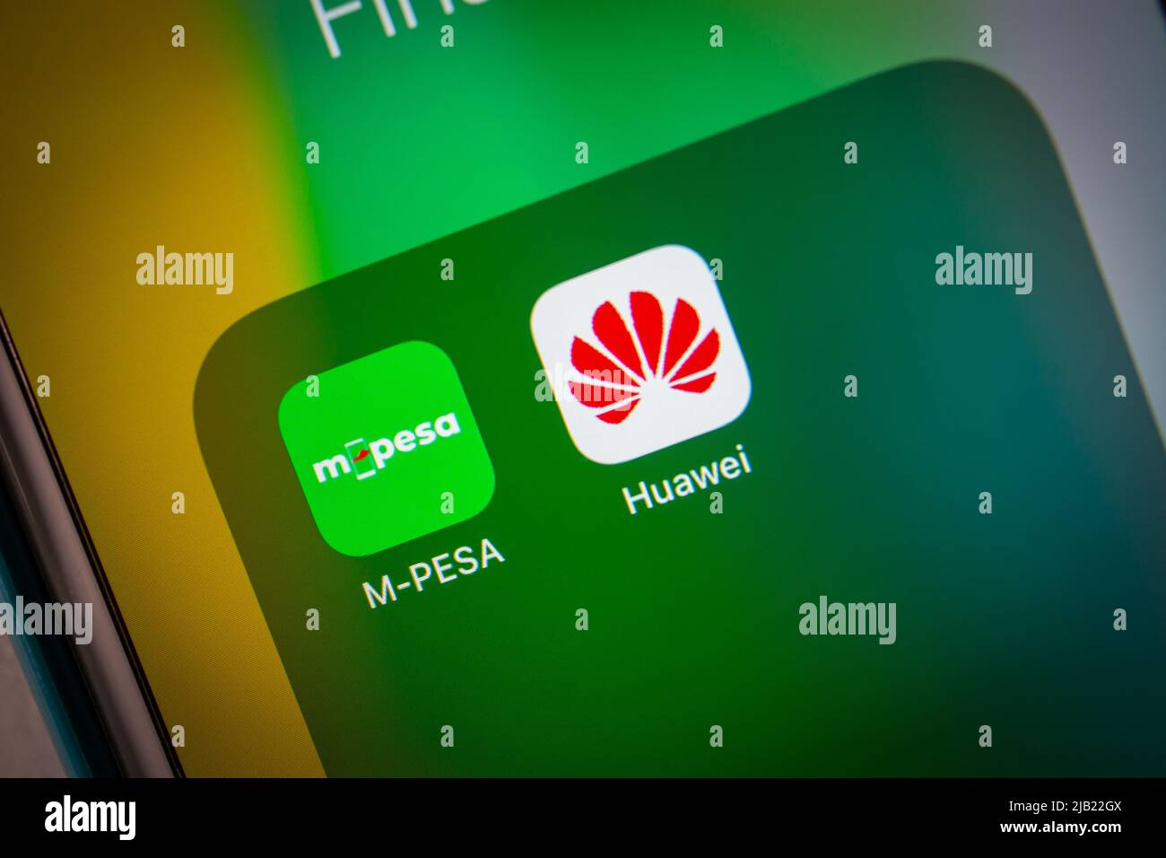 Icônes Mpesa et Huawei sur un iPhone dans l'obscurité. M-Pesa est un service de transfert d'argent et de paiement par téléphone portable de Vodafone et Safaricom Banque D'Images
