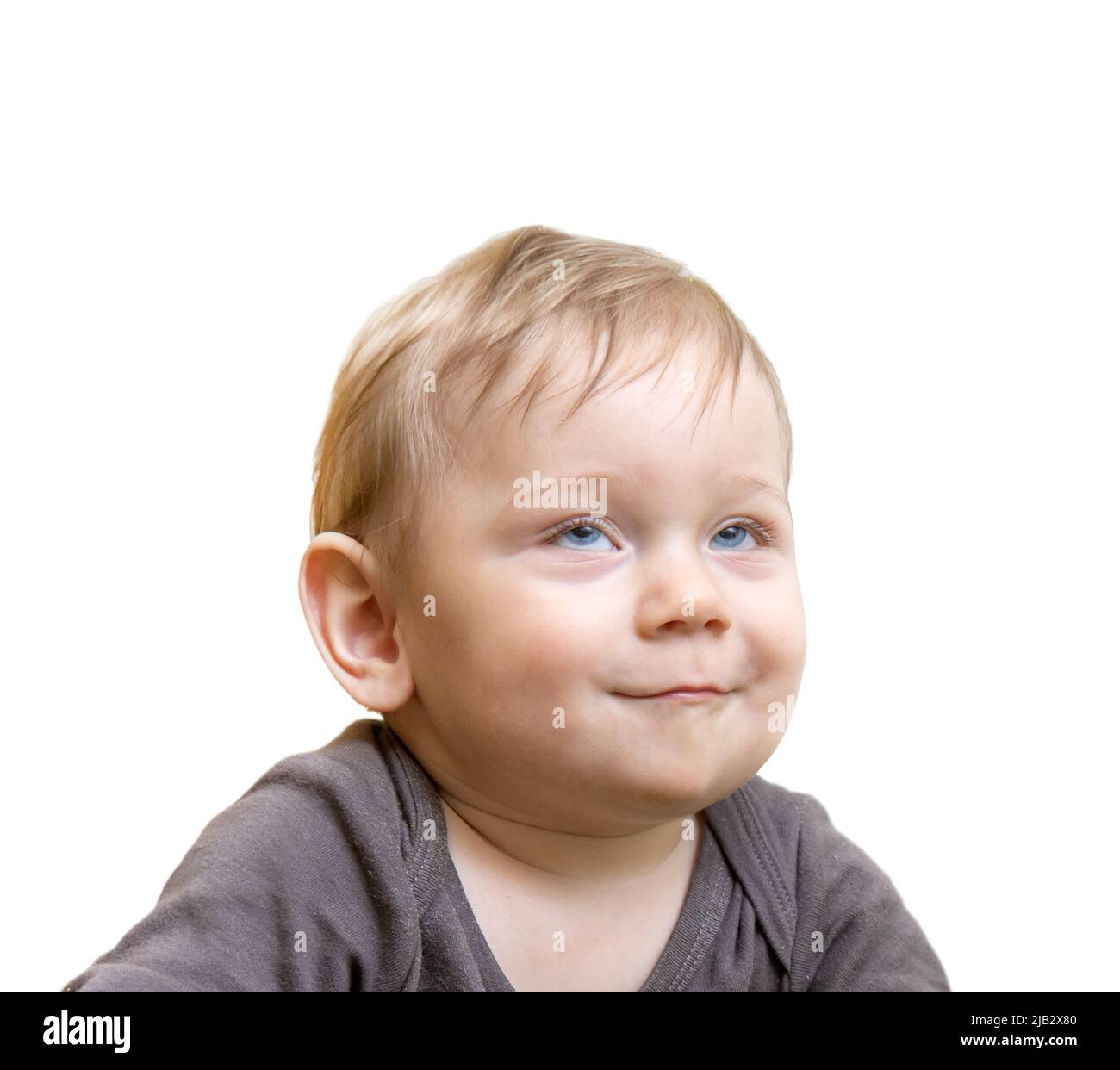 Le portrait d'un garçon souriant avec les yeux vers le haut, isolé sur fond blanc Banque D'Images