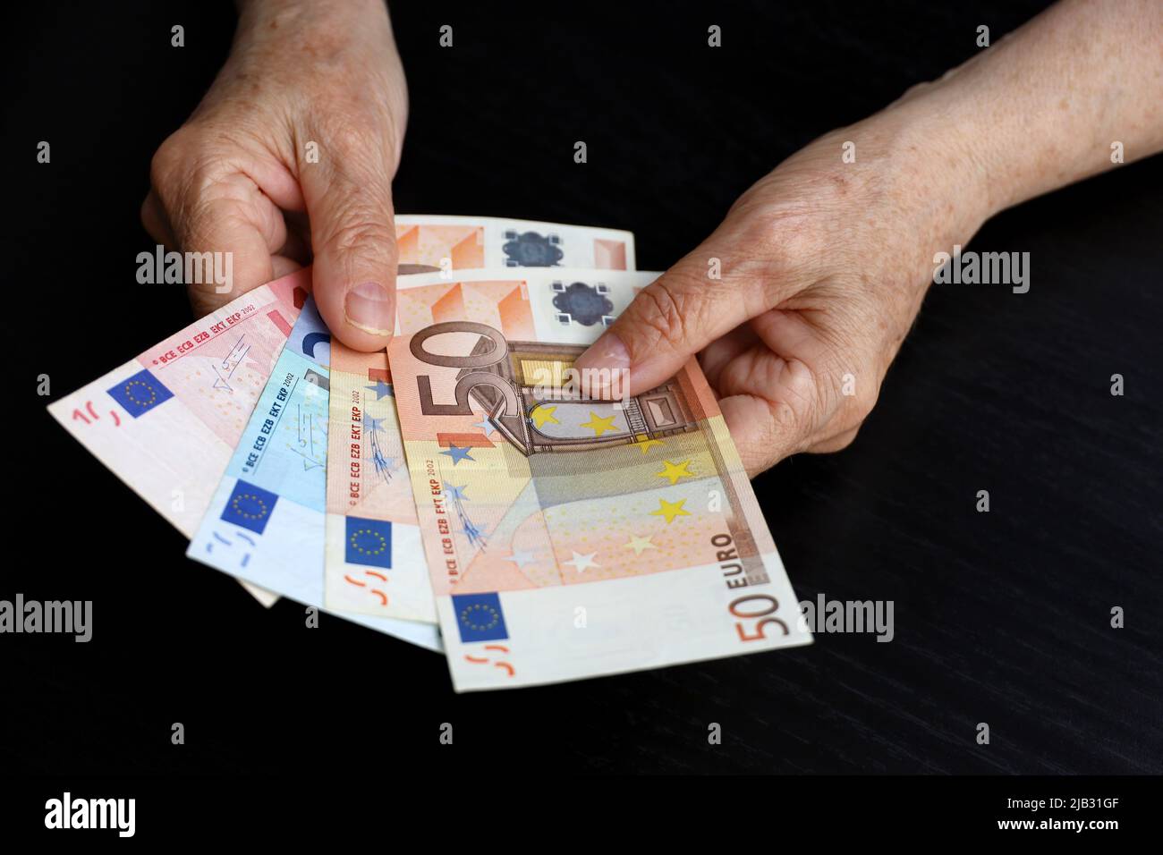 Femme âgée avec des billets d'euro dans les mains froissées. Concept des paiements de pension, de l'épargne à la retraite, du pensionné avec de l'argent Banque D'Images