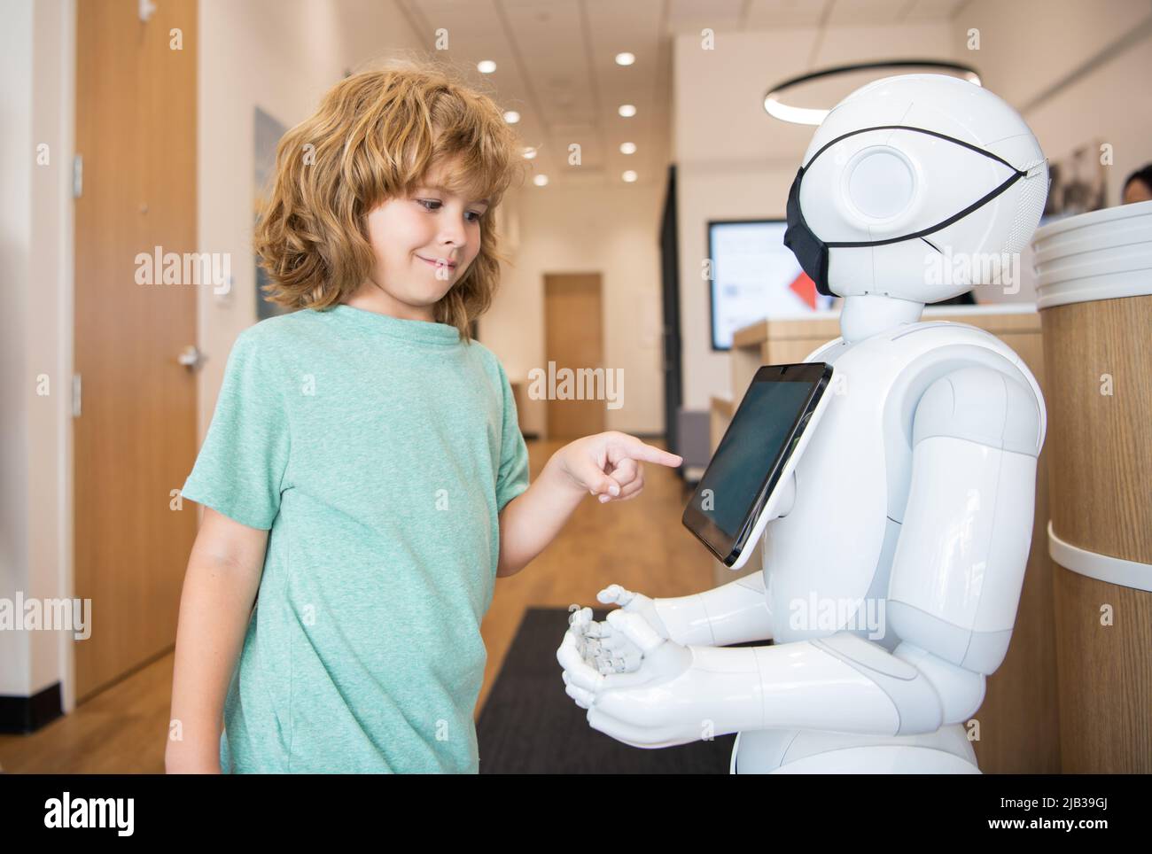 un petit garçon interagit avec l'intelligence artificielle du robot, la communication Banque D'Images