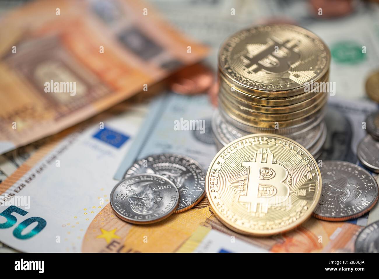 Les pièces de monnaie en bitcoin sont empilées sur les billets et pièces en dollars et en euros. La monnaie Crypto avec de l'argent papier des États-Unis et de l'Europe. Technologie blockchain exch Banque D'Images