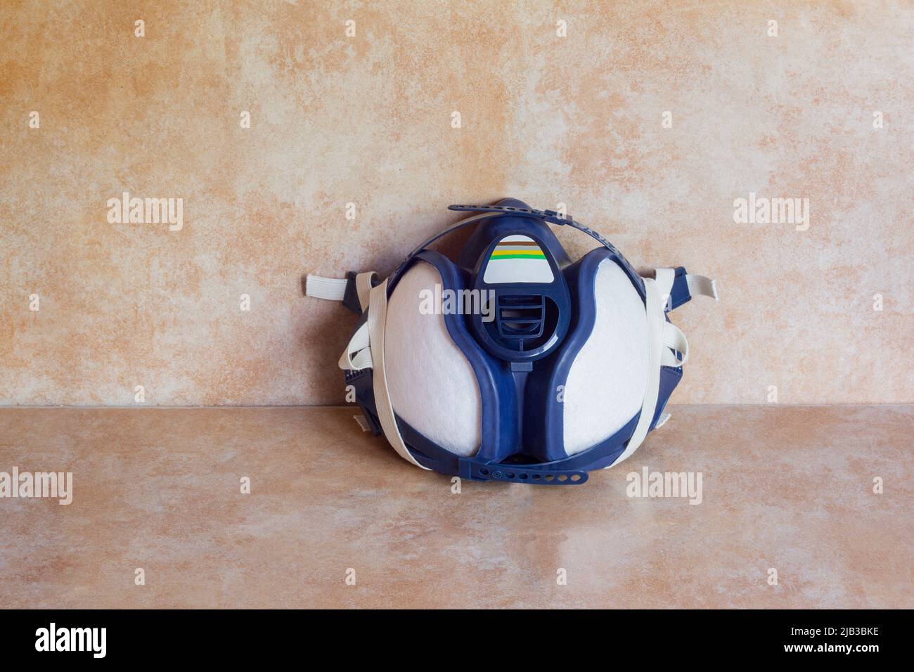 Demi-masque de gaz réutilisable isolé avec filtres sur un fond de peinture fait main studio coloré. EPI et sécurité. Banque D'Images