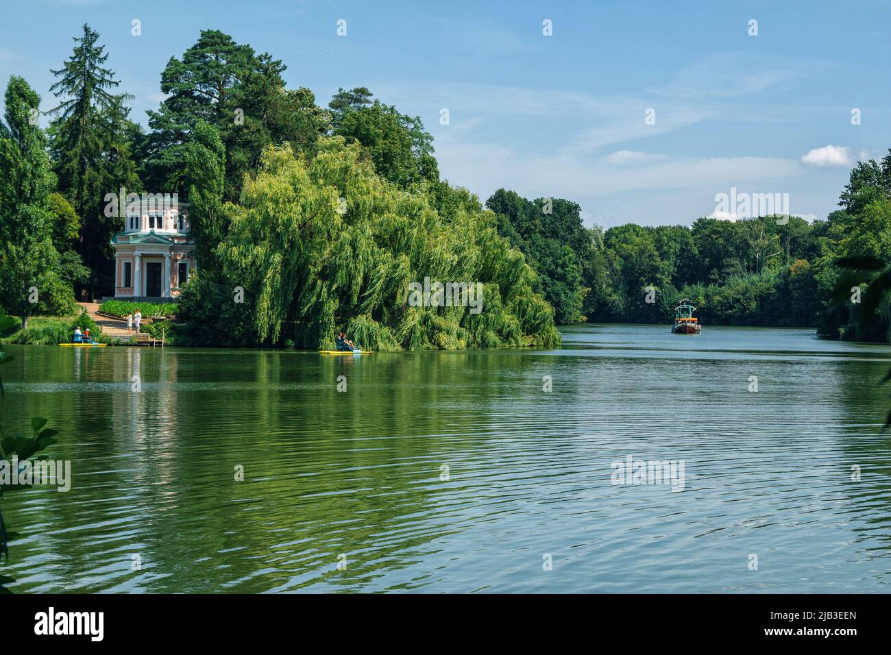 Uman, Ukraine – 5 août 2021 : magnifique paysage d'été du parc arboretum de Sofiyivka – étang, gens qui font du catamarans, feuillage luxuriant et ciel bleu Banque D'Images