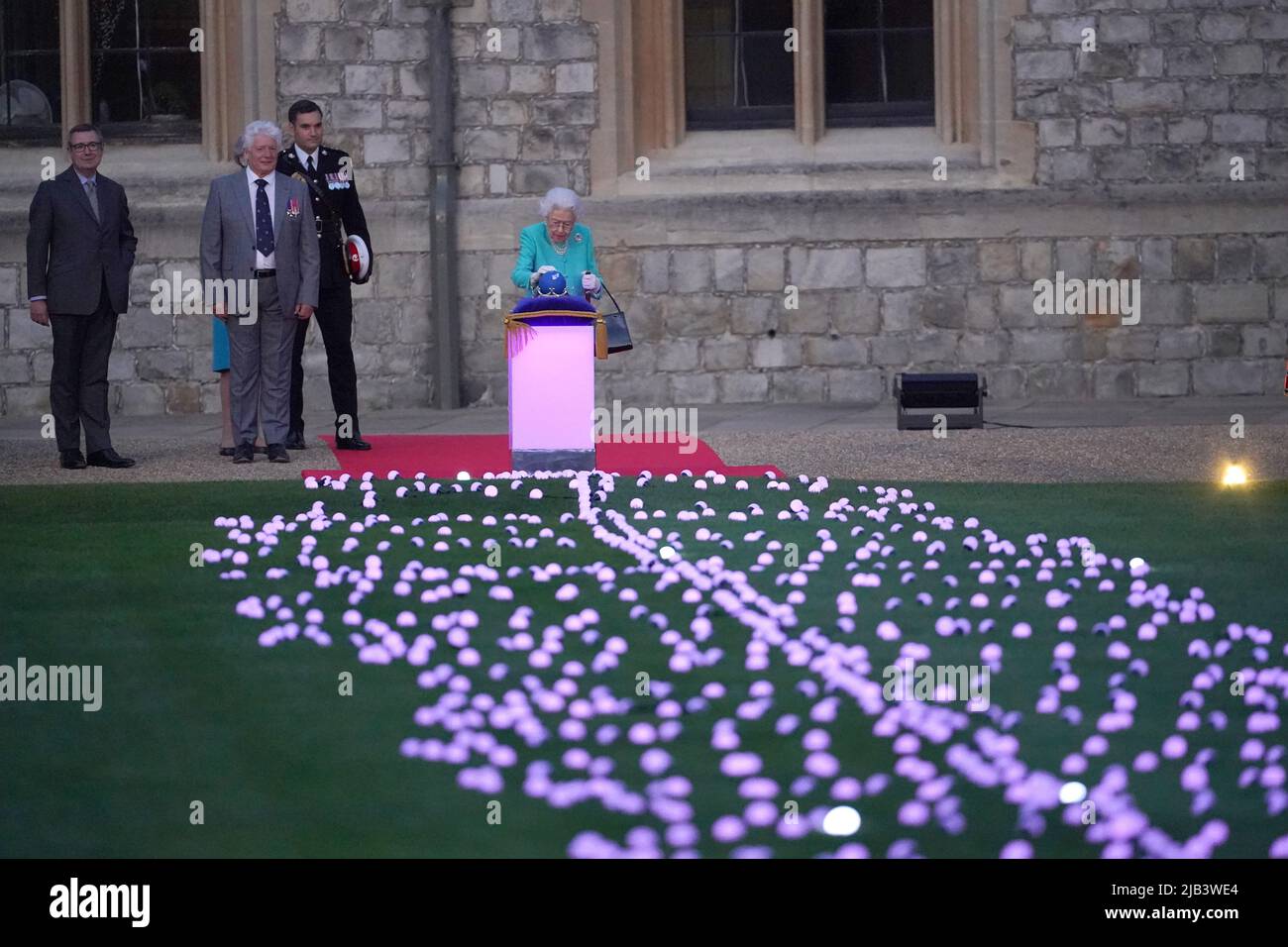 La reine Elizabeth II dirige symboliquement l'éclairage du phare principal du Jubilé au château de Windsor, dans le cadre d'une chaîne de plus de 3 500 hommages flamboyants à son règne de 70 ans, le premier jour des célébrations du Jubilé de platine. Plus de 3 000 villes, villages et villes du Royaume-Uni, des îles Anglo-Normandes, de l'île de Man et des territoires d'outre-mer du Royaume-Uni, ainsi que chacune des capitales des pays du Commonwealth, sont des balises lumineuses pour marquer le Jubilé. Date de la photo: Jeudi 2 juin 2022. Banque D'Images