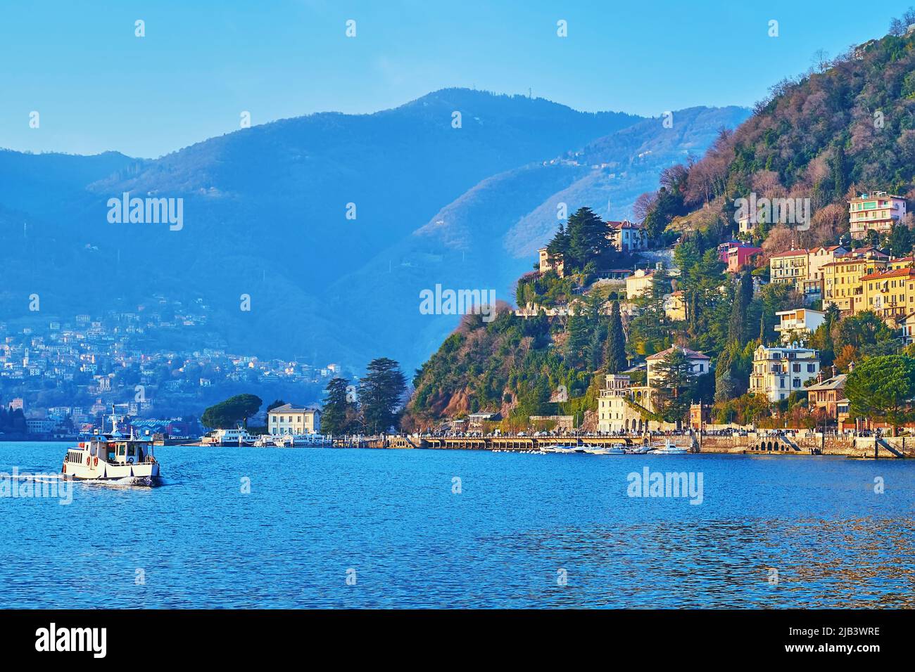 Le magnifique paysage de montagne avec des forêts verdoyantes, les vieilles villas de Côme et un ferry sur le lac de Côme, en Italie Banque D'Images Le magnifique paysage de montagne avec des forêts verdoyantes, les vieilles villas de Côme et un ferry sur le lac de Côme, en Italie Banque D'Images