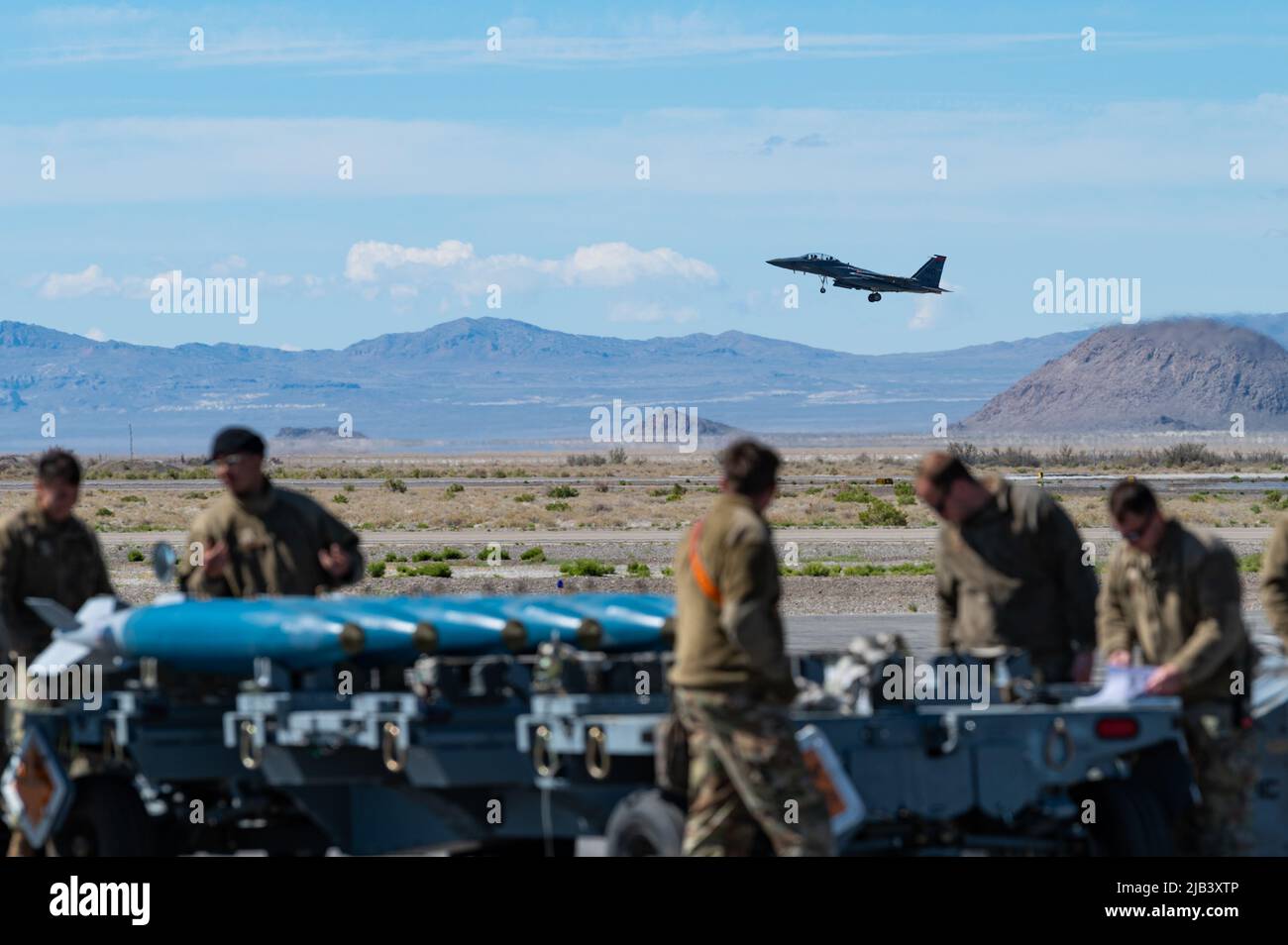 Des aviateurs de la US Air Force de la 366th Fighter Wing, base aérienne de Mountain Home, Idaho, regardent un F-15E Strike Eagle survole à l'aérodrome de Wendover, Wendover, UT., 21 mai 2022. L'escadre de combat 366th maintient deux escadrons de chasseurs qui volent le F-15E Strike Eagle : le 389th Escadron de chasseurs et le 391st Escadron de génération de chasseurs. (É.-U. Photo de la Force aérienne par le Senior Airman Cole Yardley) Banque D'Images