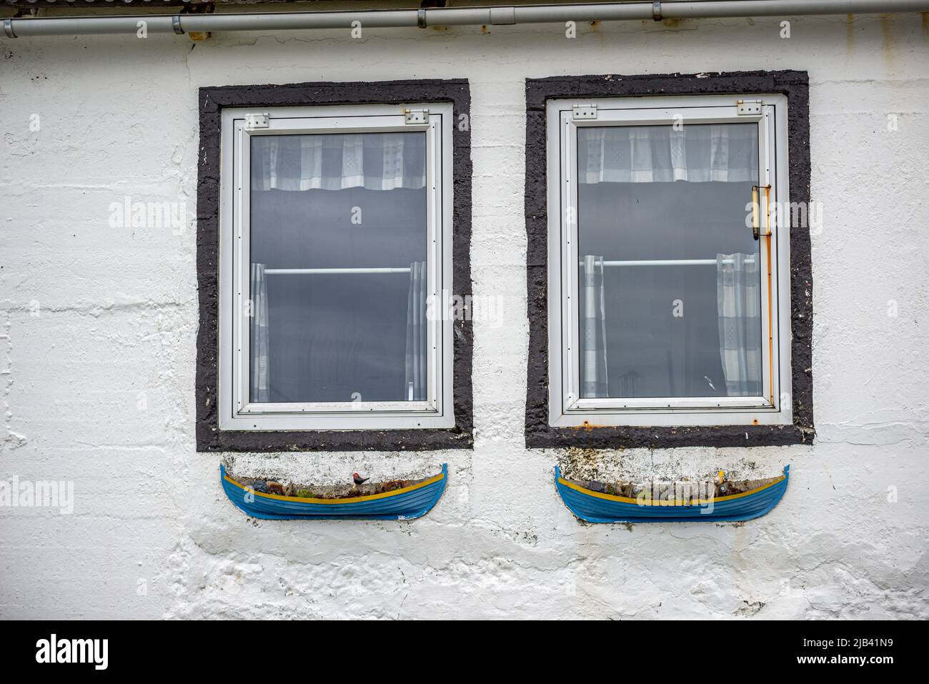 Deux fenêtres avec pots de fleurs en forme de bateaux, village de Trollanes, île de Kalsoy, îles Féroé Banque D'Images
