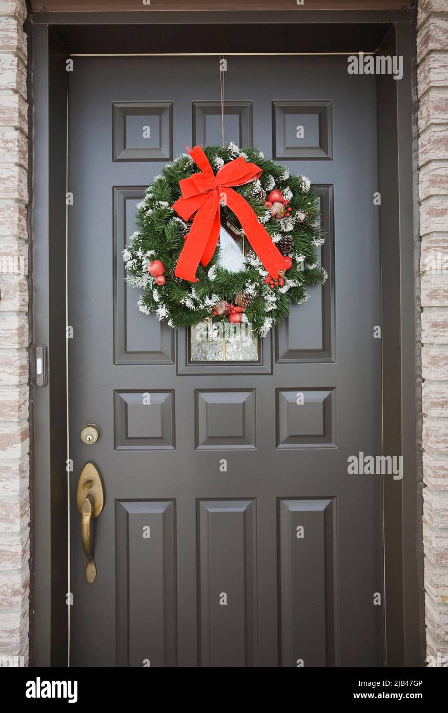 Couronne de Noël sur la porte d'entrée du petit bungalow à l'heure de Noël. Banque D'Images