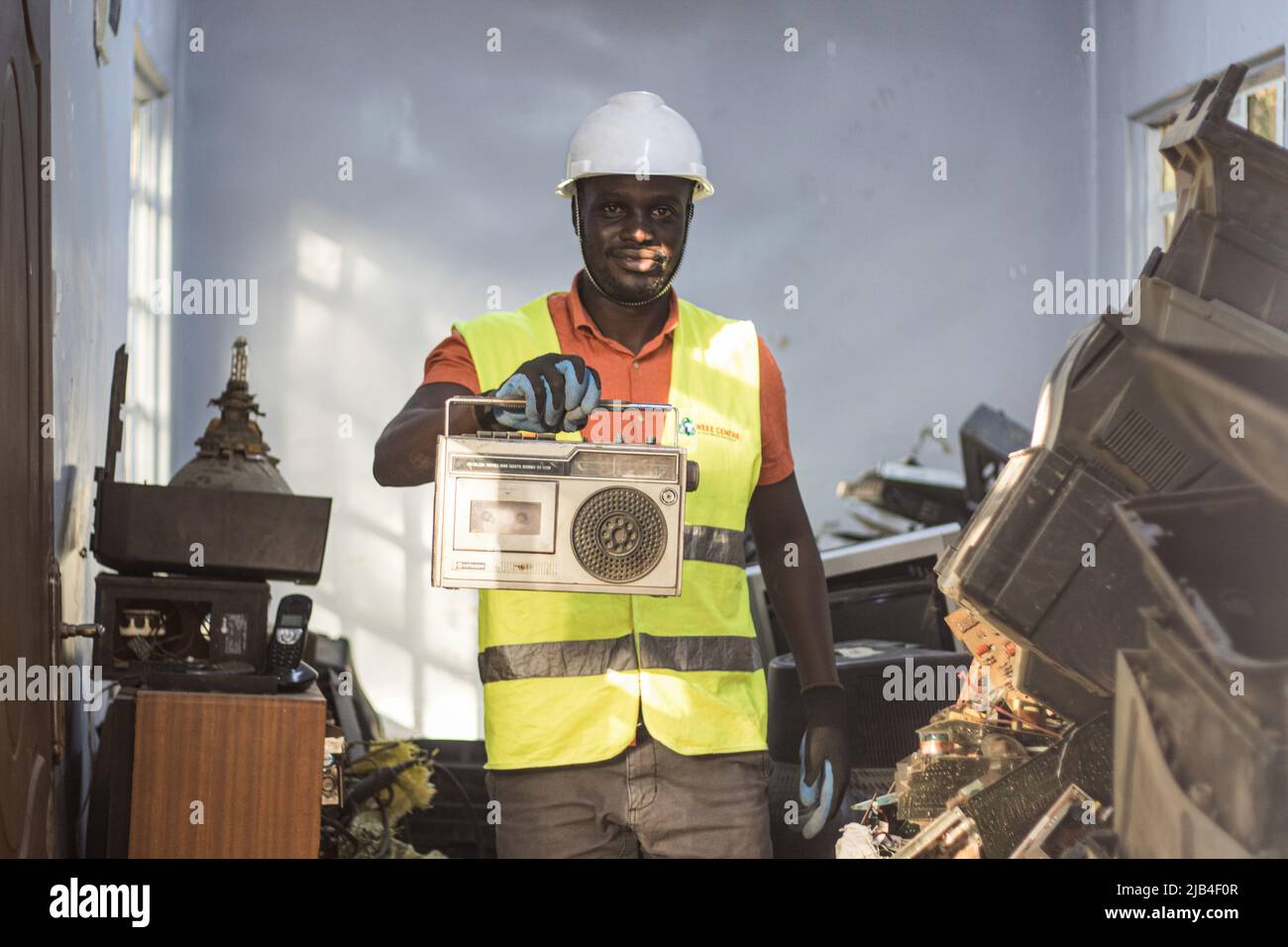 Mark Oluoch un employé des déchets électroniques du centre des déchets d'équipements électriques et électroniques (WEEE Center) présente un ancien lecteur de cassettes radio dans un centre de collecte des déchets électroniques de Nakuru avant d'être ensuite transporté à Nairobi pour recyclage. Le Kenya produit environ 11 000 tonnes métriques de déchets électroniques chaque année, la plupart de ces déchets contiennent des produits chimiques nocifs comme le plomb, le mercure et le phosphore. Des appels sont lancés pour augmenter les taux de collecte et de recyclage des déchets électroniques et plastiques afin de protéger l'environnement et la santé publique. Banque D'Images