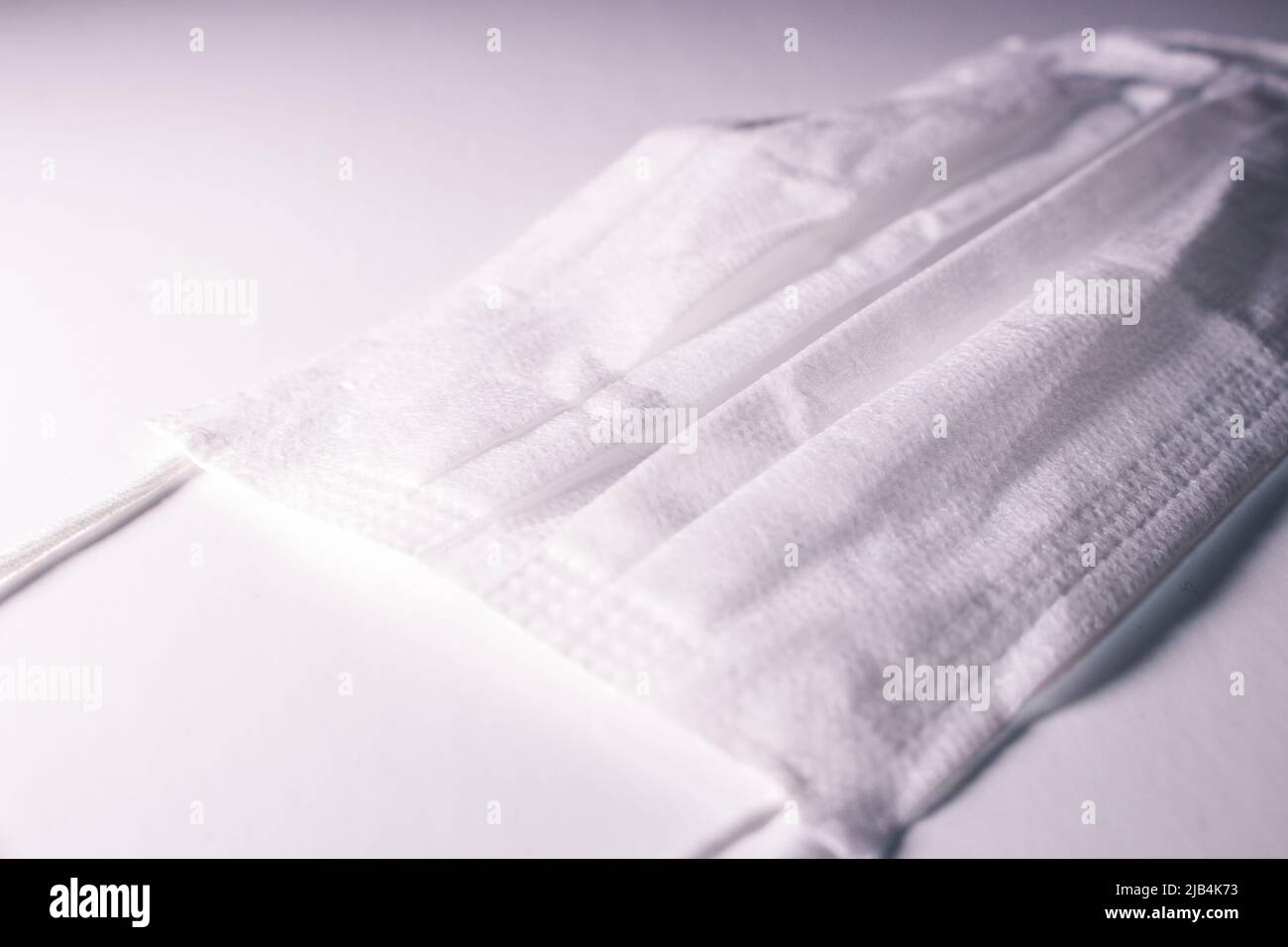 Pile de masques blancs (couvre-visage) sur fond blanc. Banque D'Images