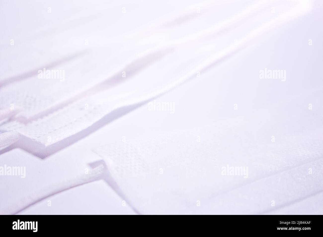 Pile de masques blancs (couvre-visage) sur fond blanc. Banque D'Images