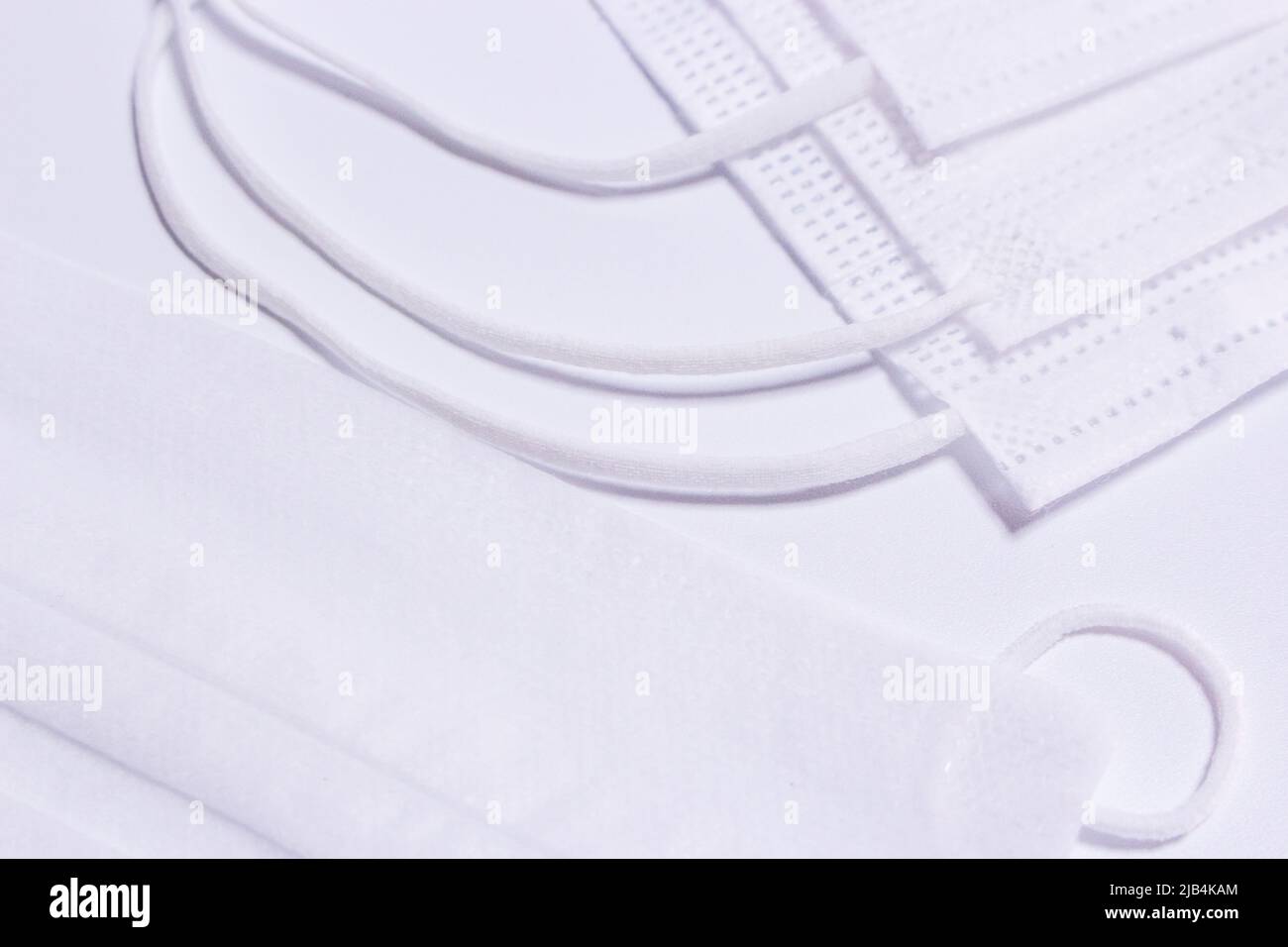 Pile de masques blancs (couvre-visage) sur fond blanc. Banque D'Images