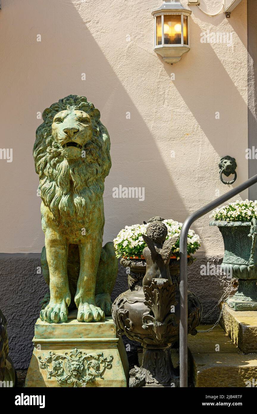 Lion de bronze et petit ange avec fleurs devant la façade, Oberstaufen, Allgaeu, Bavière, Allemagne Banque D'Images