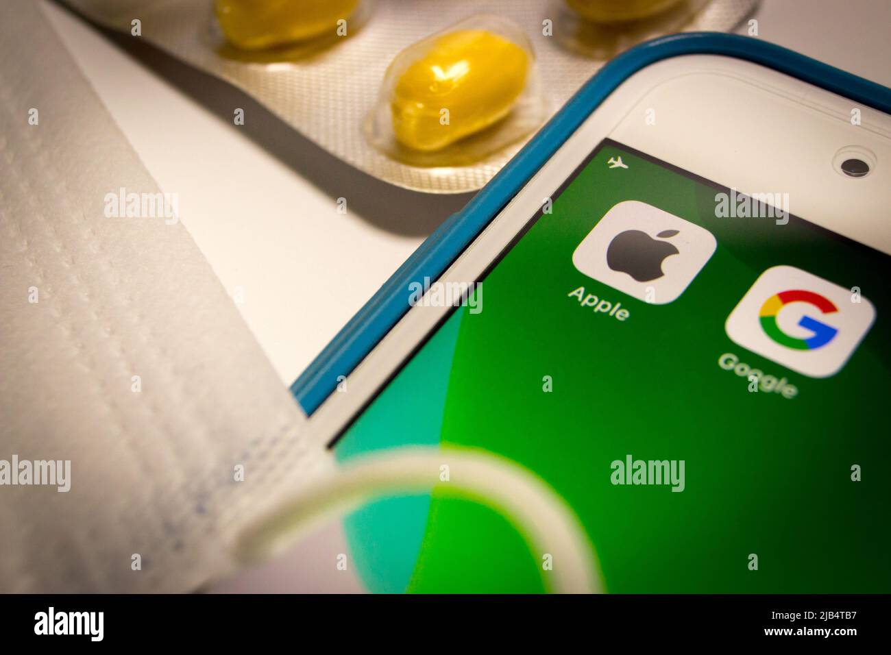 Kumamoto, Japon - 7 mai 2020 : image concept du logo Apple et Google sur l'écran de l'iPhone avec des pilules et un masque facial sur fond blanc. Banque D'Images