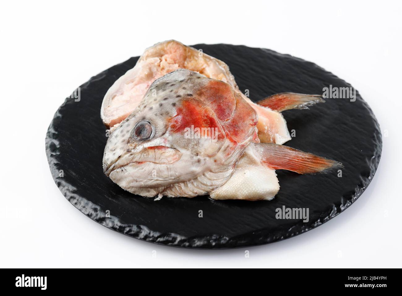 Tête de poisson de saumon surgelé sur plaque d'ardoise noire, espace de copie pour le texte Banque D'Images