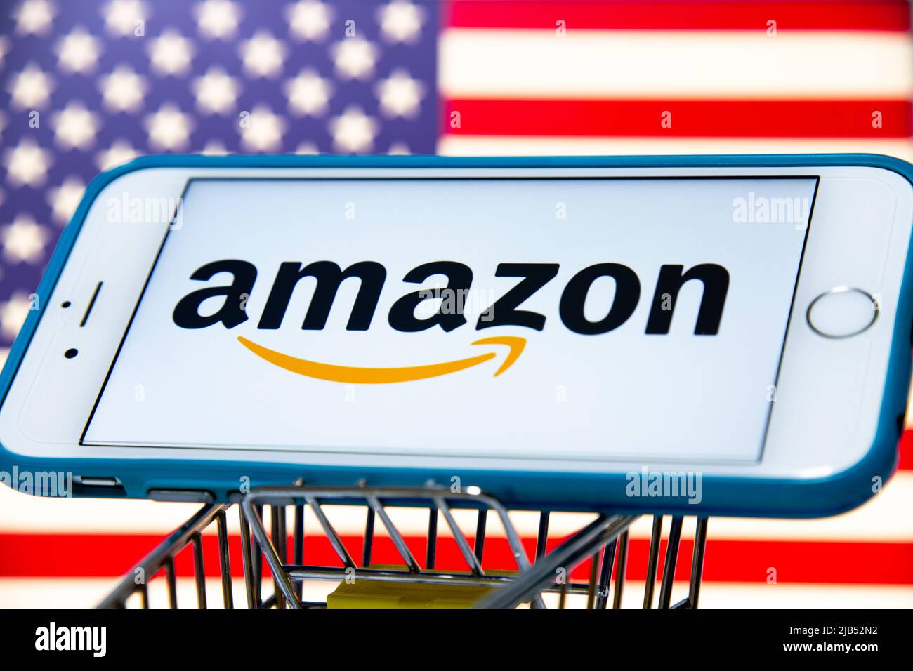 Le logo d'Amazon, une société multinationale américaine de technologie basée à Seattle, Washington, sur iPhone dans un panier avec drapeau américain Banque D'Images