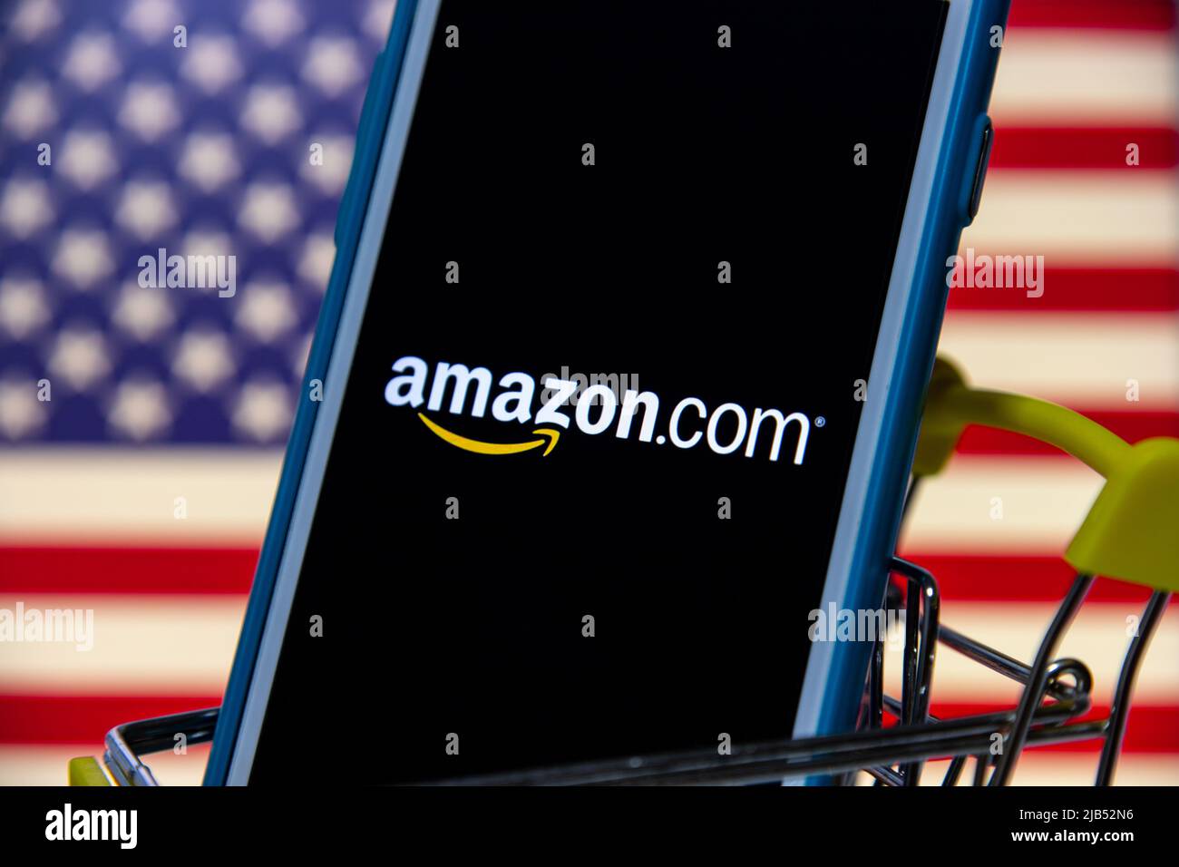 Le logo d'Amazon, une société multinationale américaine de technologie basée à Seattle, Washington, sur iPhone dans un panier avec drapeau américain Banque D'Images