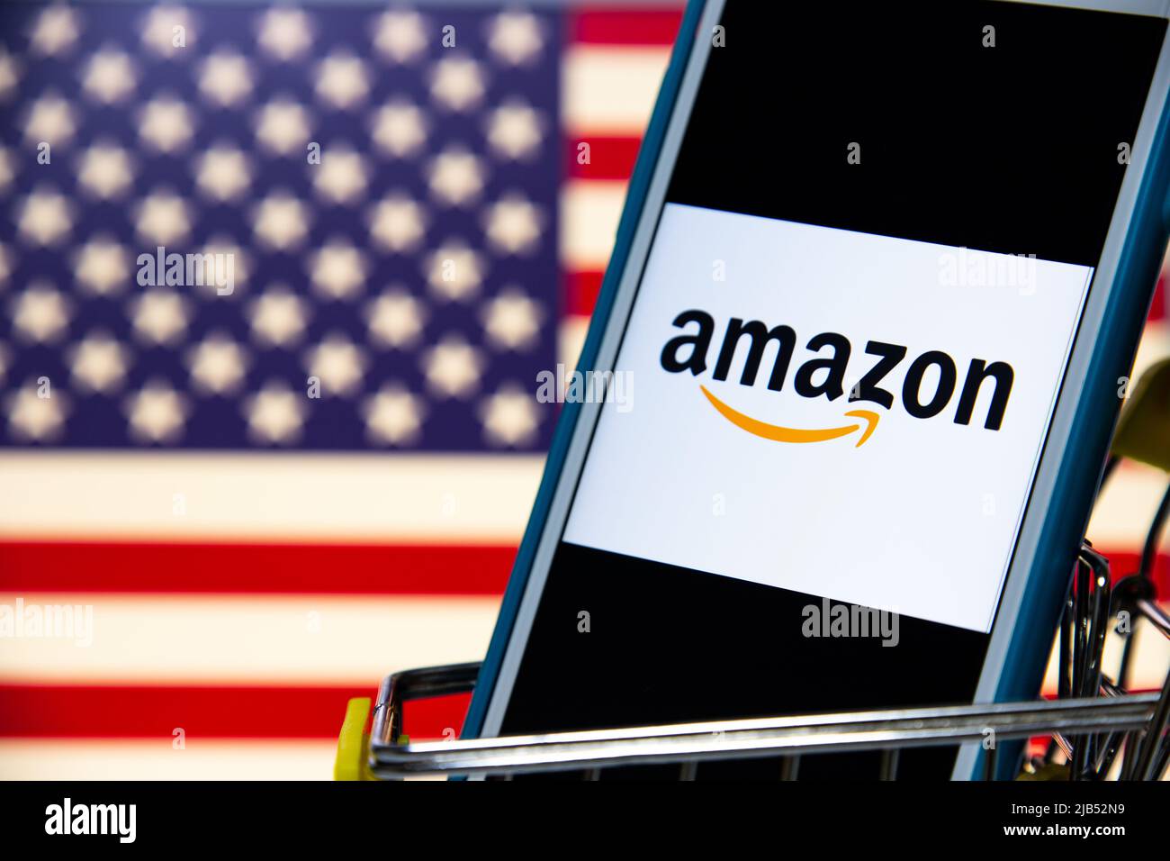 Le logo d'Amazon, une société multinationale américaine de technologie basée à Seattle, Washington, sur iPhone dans un panier avec drapeau américain Banque D'Images