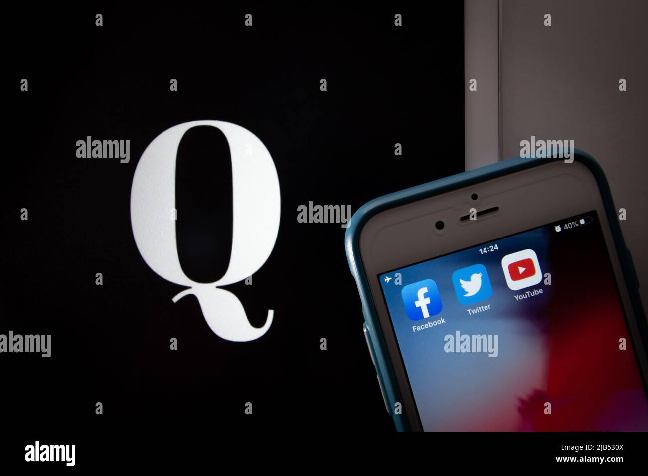 Kumamoto / JAPON - octobre 20 2020 : le logo de Qanon, un groupe de conspiration d'extrême droite, sur tablette avec Facebook, Twitter et YouTube apps sur iPhone. Banque D'Images