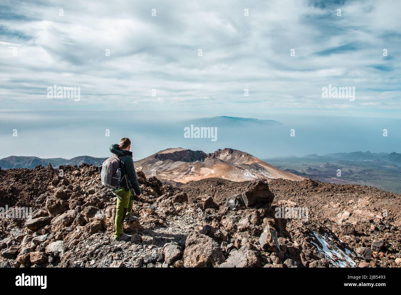 Jeune homme au sommet du volcan El Teide à Ténérife ou montagne en regardant la vallée avec une vue splendide. Rater du volcan Pico Viejo Banque D'Images