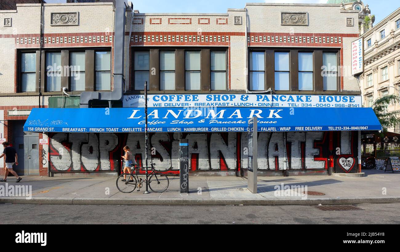 Une personne passe devant le café Landmark Coffee Shop avec « la haine asiatique » peint sur les portes à roulettes dans le quartier chinois de Manhattan/Little Italy, 31 mai 2022. Banque D'Images