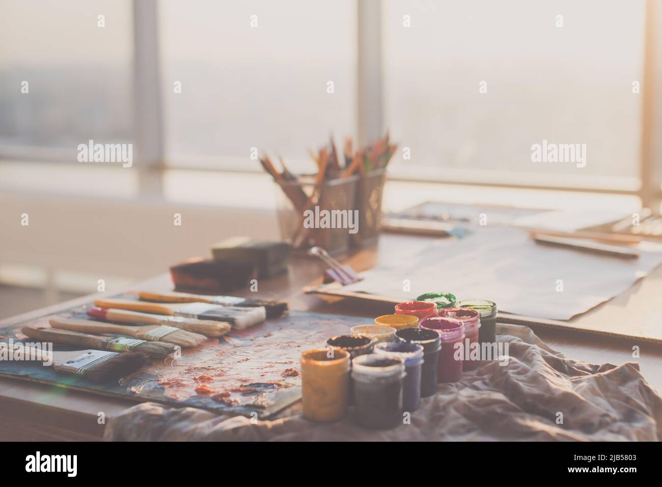 Vue en angle de la palette avec des peintures à l'huile mélangée, gouache, crayons et pinceaux dans le studio d'art Banque D'Images