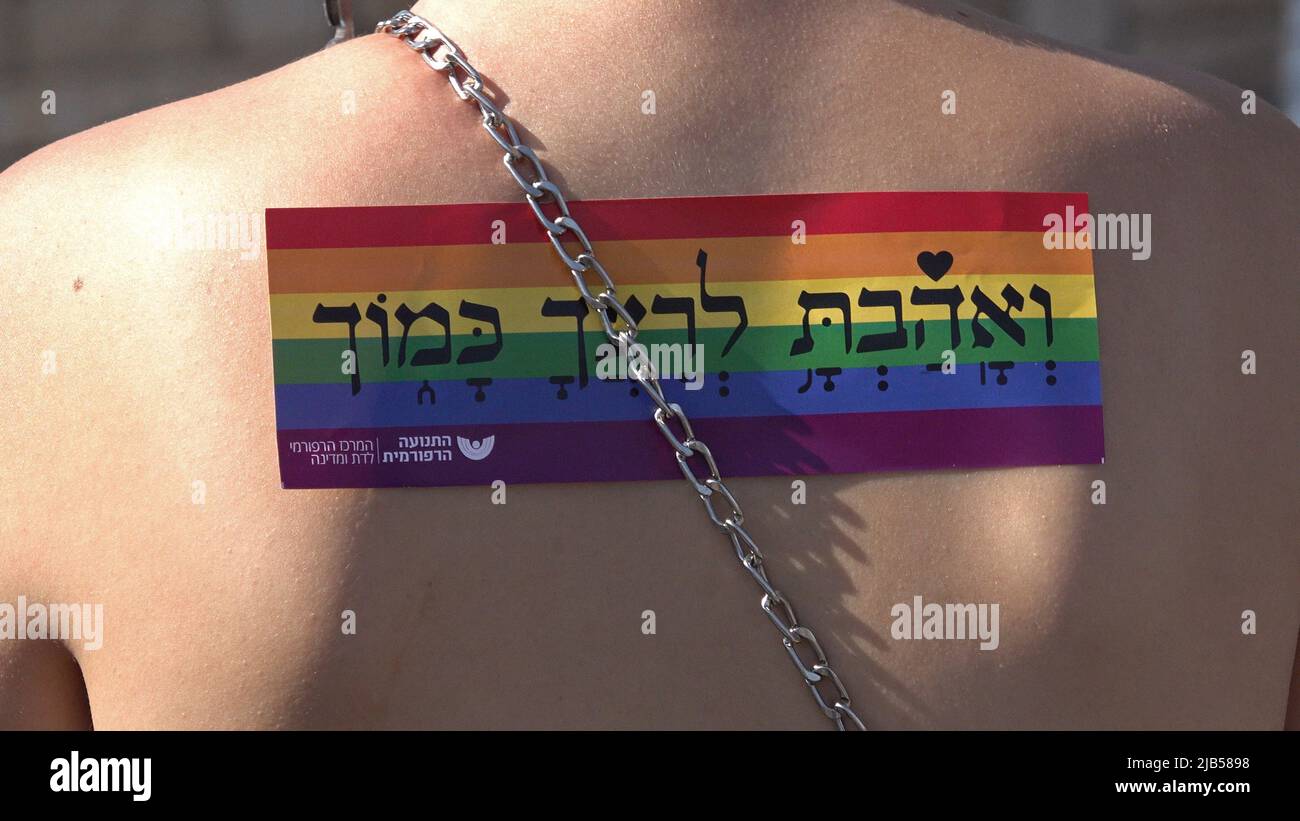 JERUSALEM, ISRAËL - JUIN 02 : une participante avec un autocollant de drapeau arc-en-ciel sur son dos avec le verset biblique « Love Your Fellow as You » pendant le défilé annuel de la fierté gay de Jérusalem dans le cadre de la célébration internationale du mois de la fierté LGBT le June0 2, 2022 à Jérusalem, Israël. Le Jerusalem gay Pride Parade rencontre souvent des contre-manifestations le long de son trajet, et parfois avec la violence. Les dirigeants de la communauté Haredi et d'autres groupes religieux appellent à son annulation chaque année. Crédit : Eddie Gerald/Alay Live News Banque D'Images