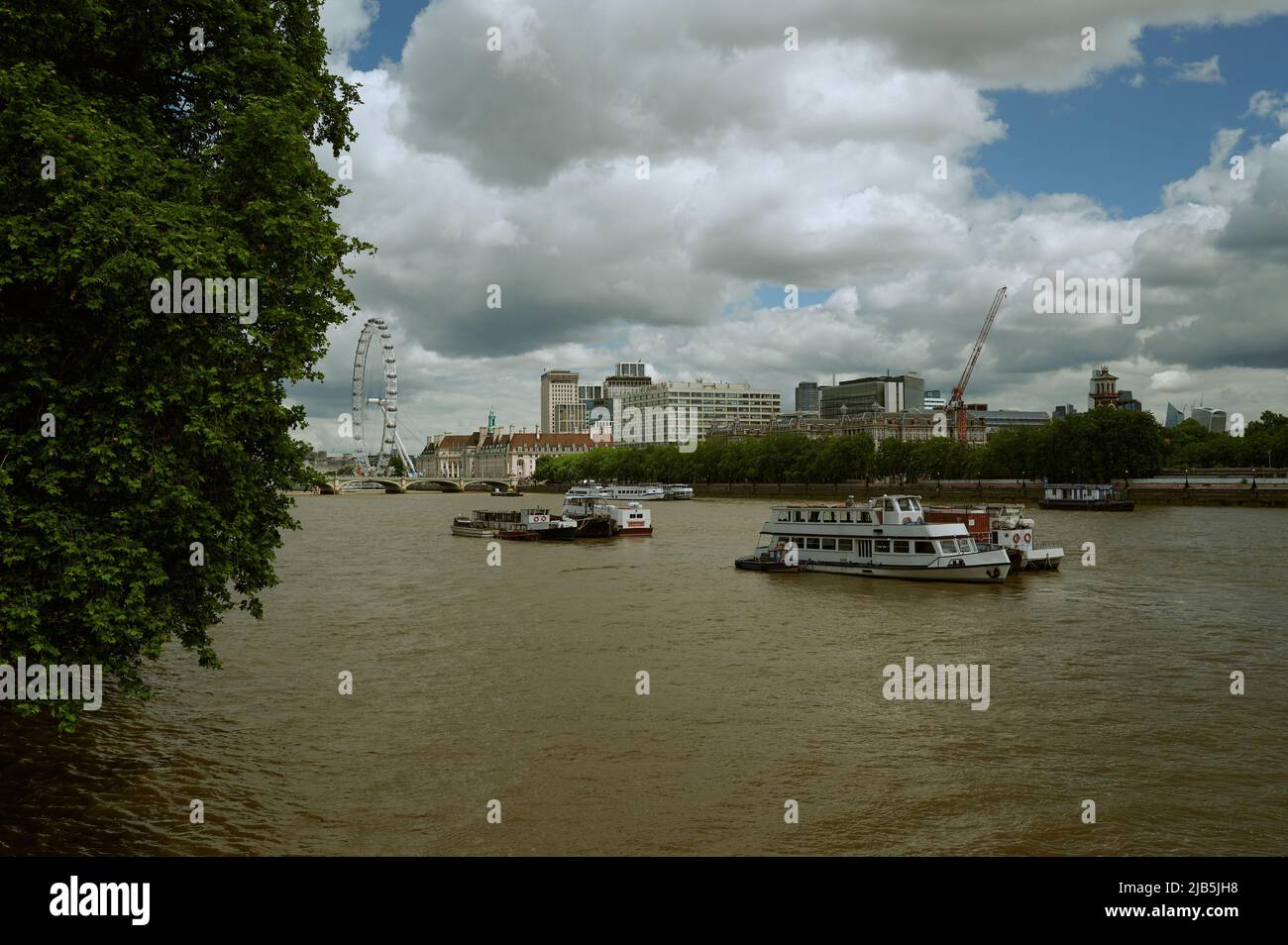 Vue sur la Tamise de couleur marron/colorée de Londres par beau temps avec des nuages vers london Eye et l'hôpital St thomas Banque D'Images