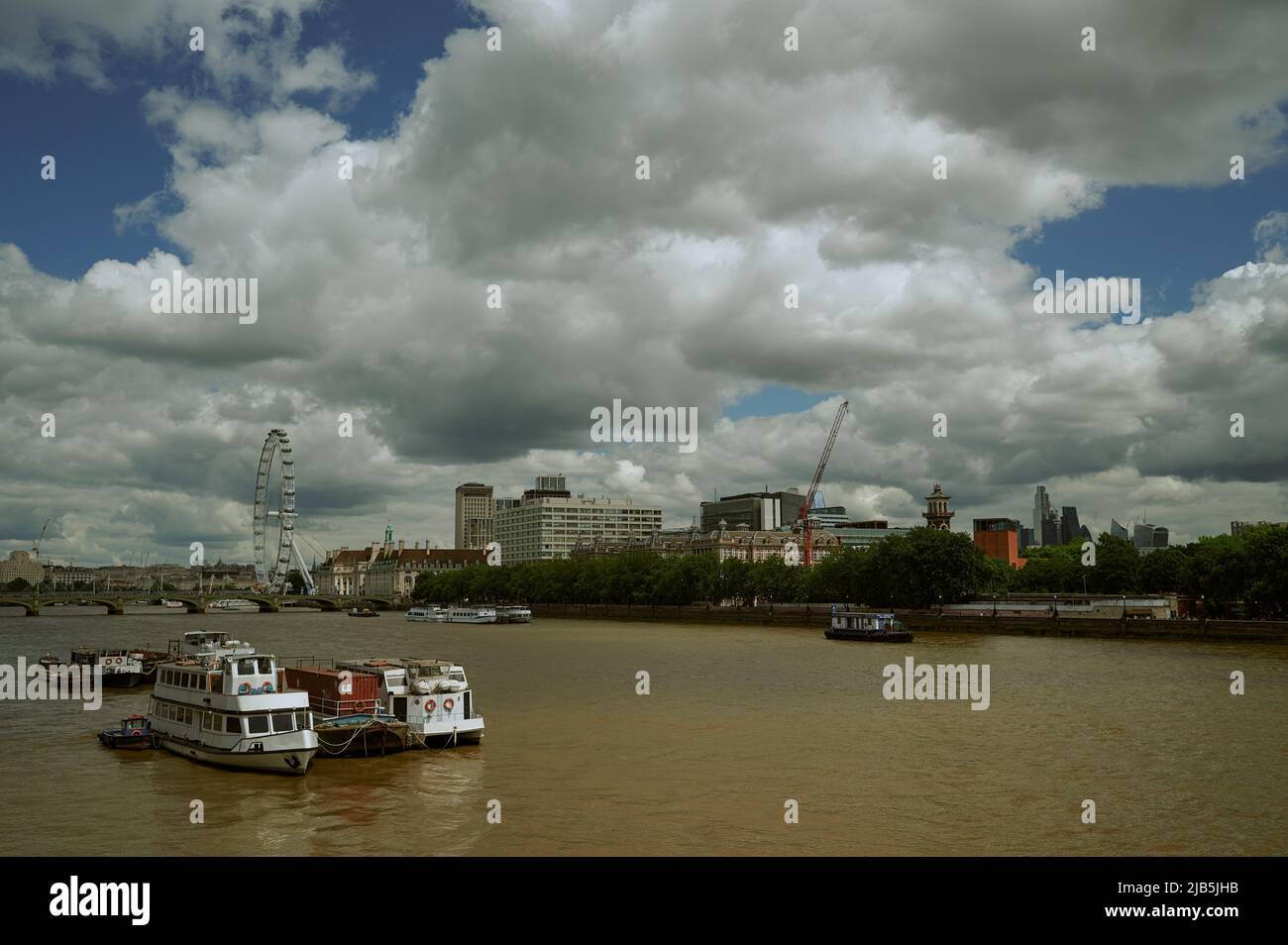 Vue sur la Tamise de couleur marron/colorée de Londres par beau temps avec des nuages vers london Eye et l'hôpital St thomas Banque D'Images