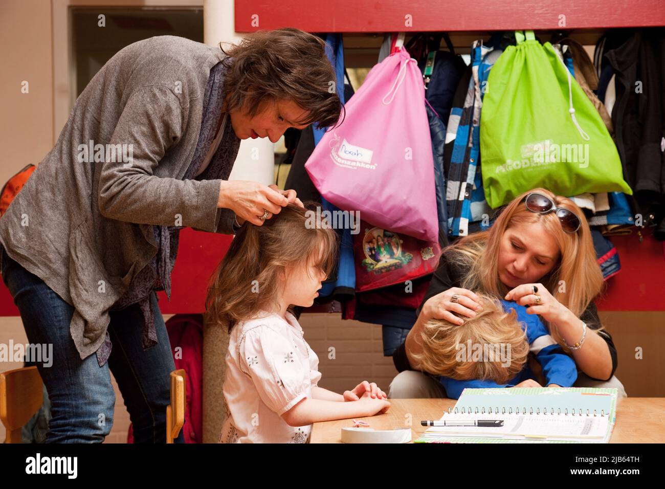 Pays-Bas, Arnhem. École primaire. Les mères sont à la recherche de puces dans les cheveux des écoliers pendant l'école. Banque D'Images