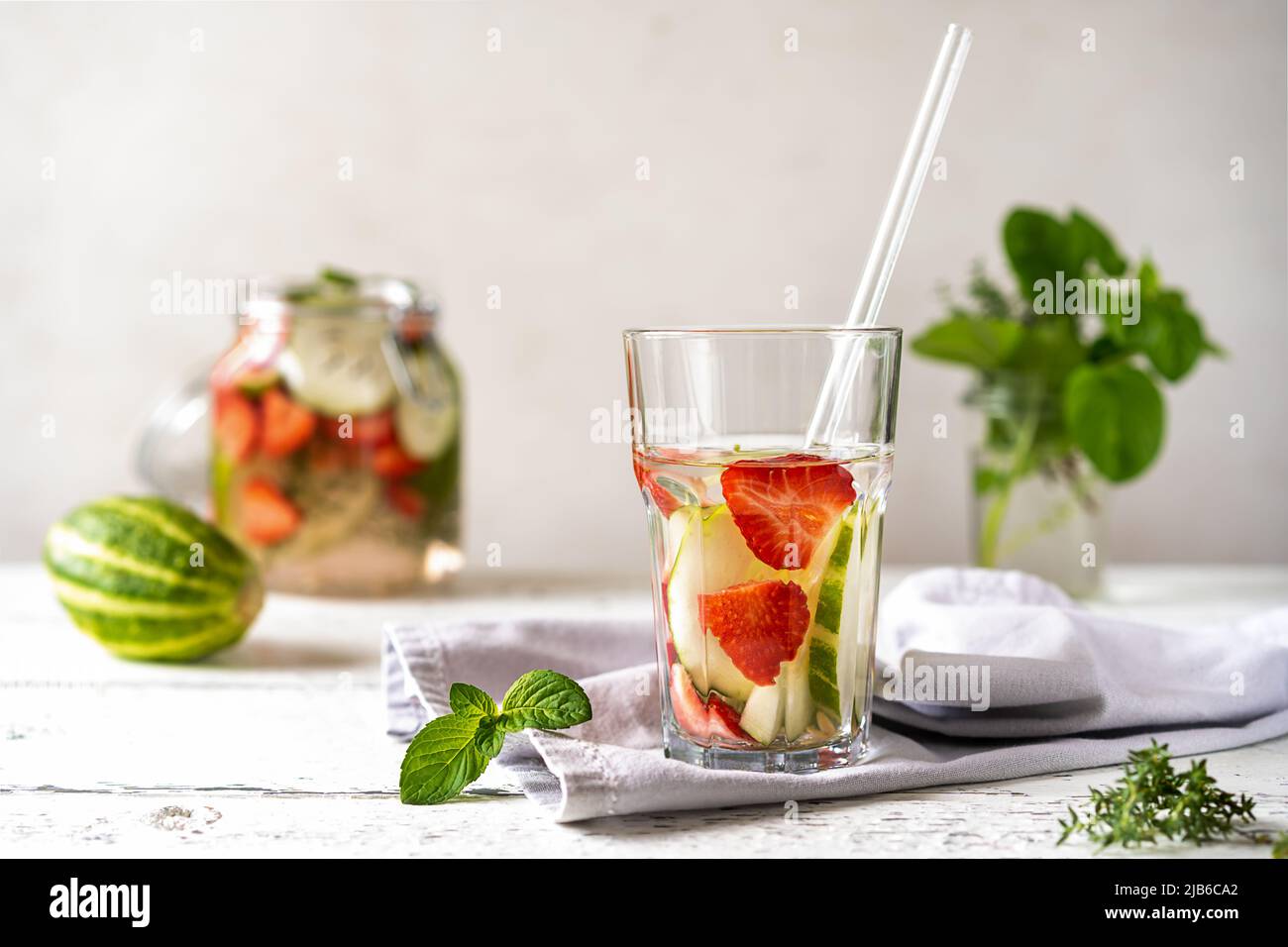 Eau infusée avec fraise et meloncella qui est hybride de concombre et melon, thym, menthe. Banque D'Images