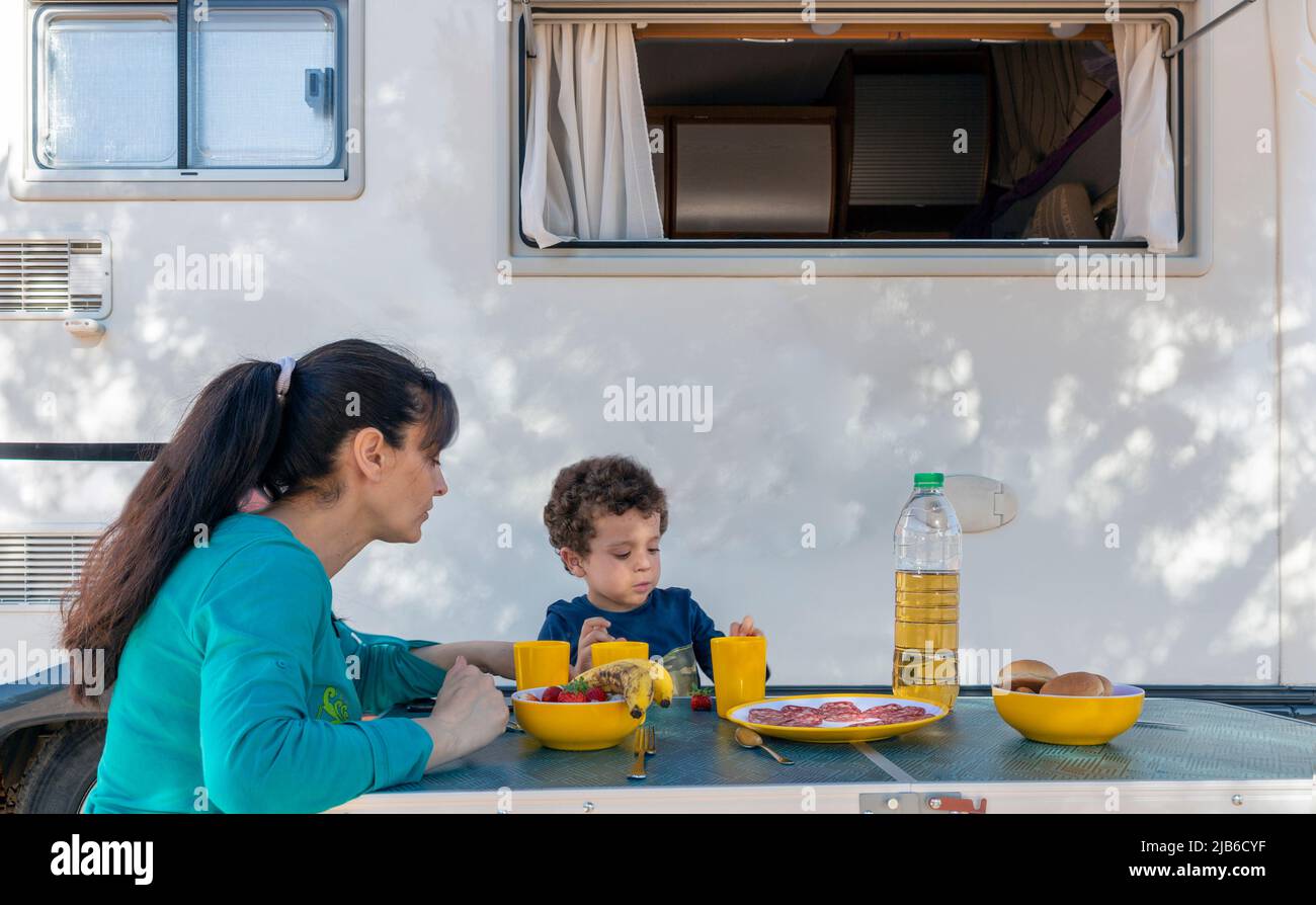 la mère et le fils pique-niquer à côté du camping-auto Banque D'Images