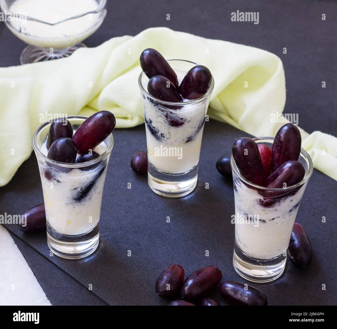 Boisson d'été Lassi, saine, douce, fraîche boisson biologique à base de yaourt glacé, dahi ou caillé et raisins rouges.smoothie aux fruits indiens sur fond noir. Banque D'Images