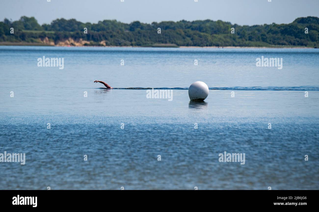 Stralsund, Allemagne. 03rd juin 2022. Un athlète nage dans le Strrelasund. Le Strrelasund sépare l'île de Rügen du continent à Stralsund. L'eau de baignade sur les côtes et les lacs de Mecklembourg-Poméranie-Occidentale est principalement d'excellente qualité. C'est le résultat du rapport annuel sur les eaux de baignade de l'Agence européenne pour l'environnement et de la Commission européenne. Dans des cas isolés, les zones de baignade dans le Mecklembourg-Poméranie occidentale ont également reçu le grade 'bon' ou 'sufficient'. Credit: Stefan Sauer/dpa/Alay Live News Banque D'Images