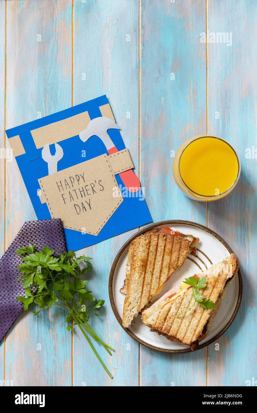 Célébration de la fête des pères. Petit déjeuner. Carte de fête des pères et sandwich maison avec bacon sur table en bois. Vue de dessus. Copier l'espace. Banque D'Images