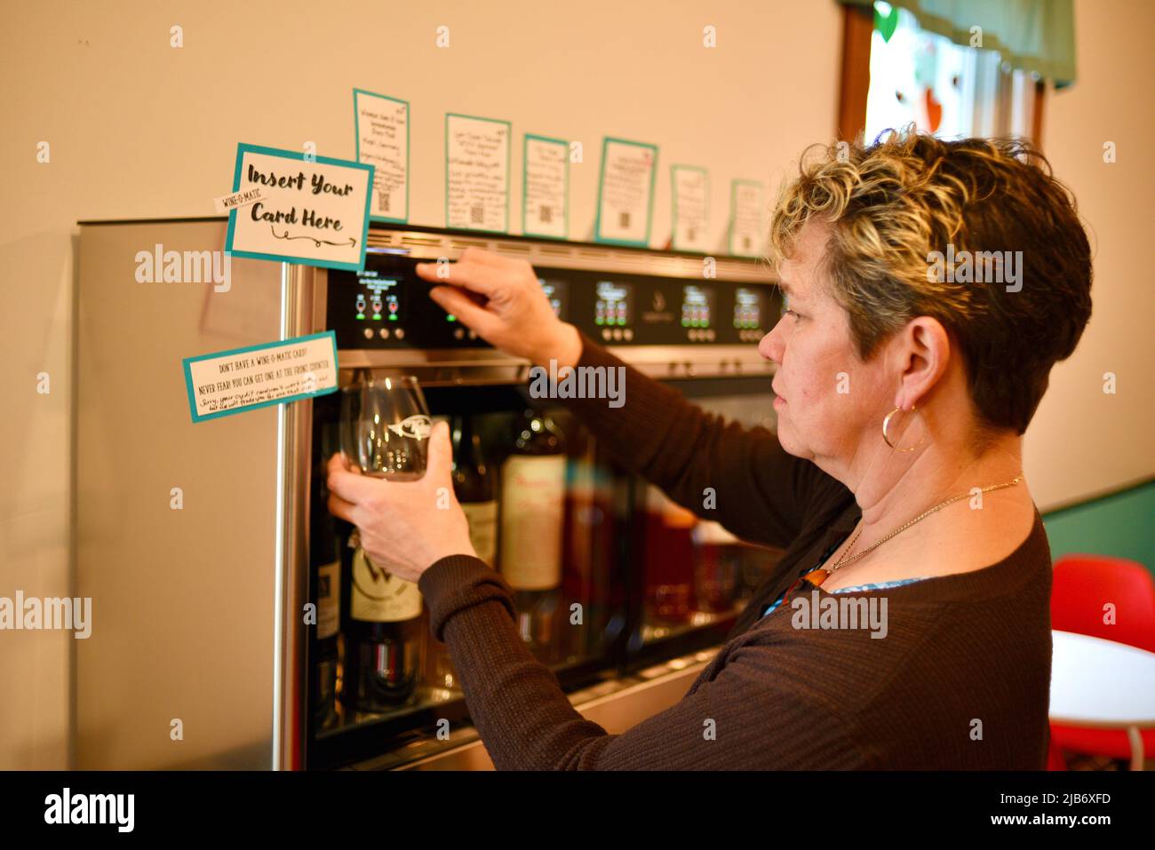 Femme cliente utilisant un système automatisé de distribution de vin, Wine-E-Motion, utilisant une carte Wine-O-Matic chez Vintage, Elkhart Lake, Wisconsin, États-Unis Banque D'Images